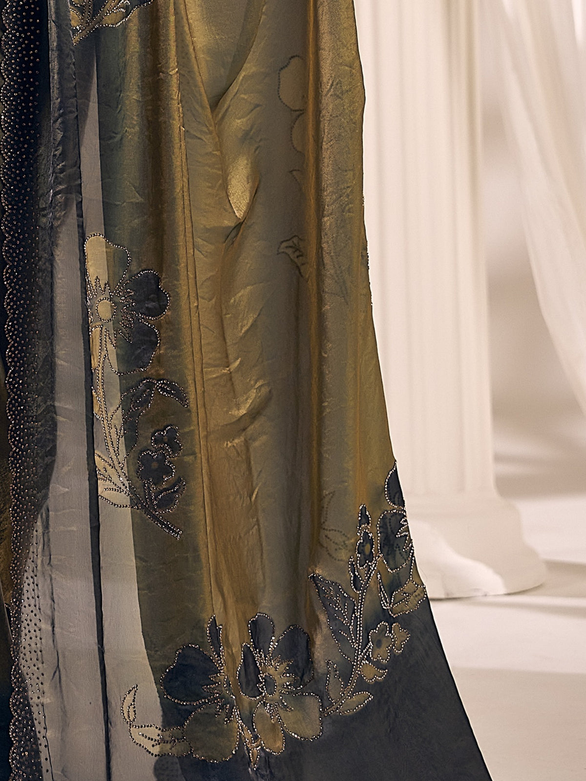 Pallu detail of olive satin silk saree showing ornamented surface design and scallop border