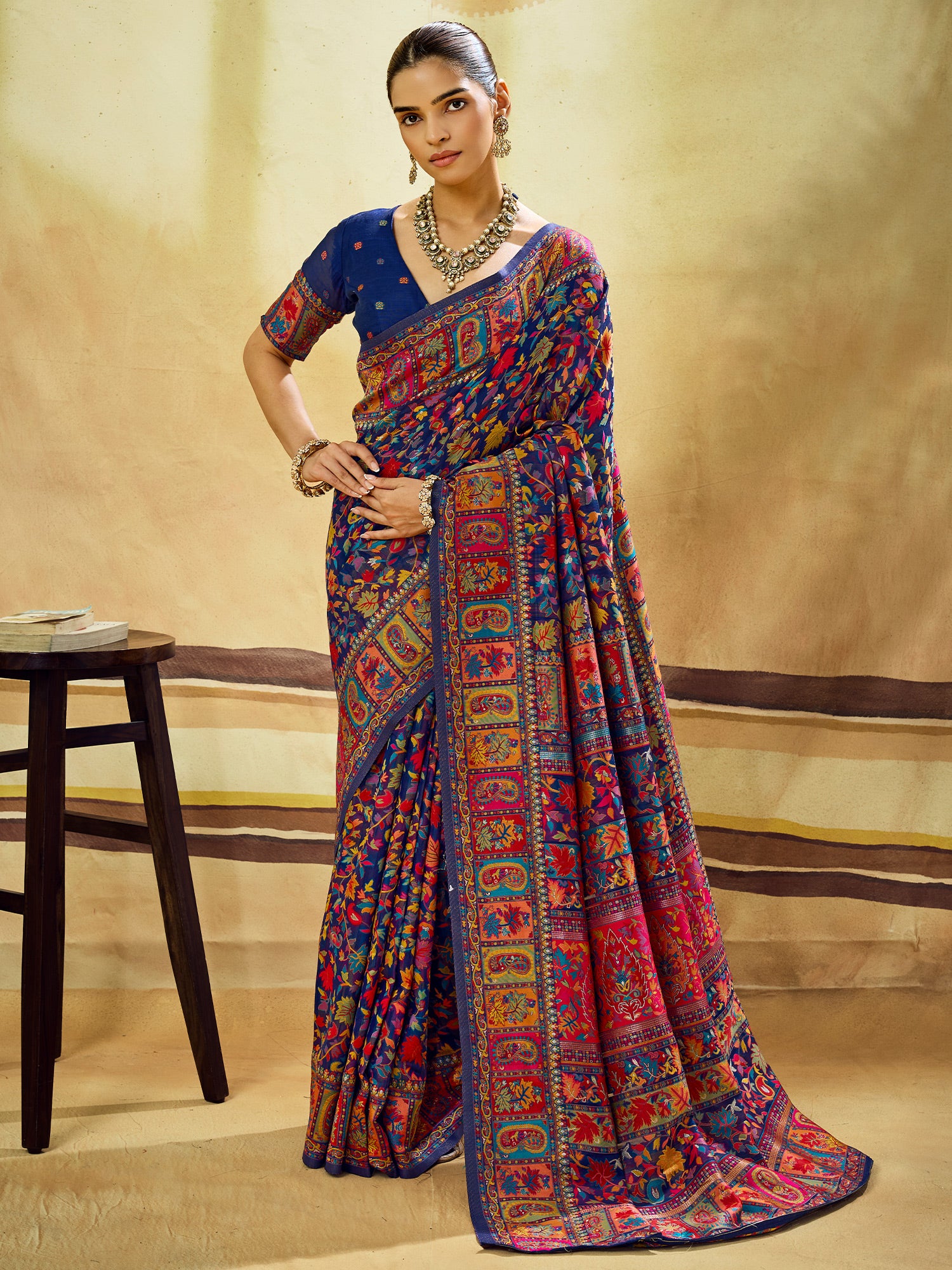 Woman wearing navy blue muga cotton saree with traditional indian motif work and navy blue blouse