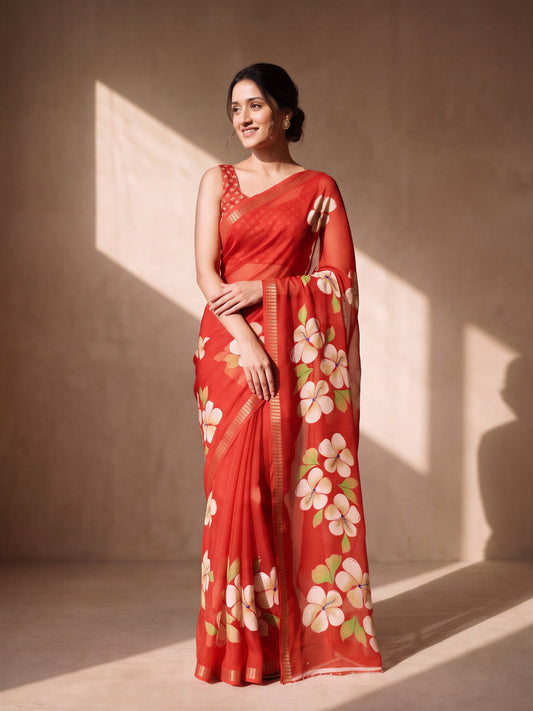 Woman wearing red georgette saree with all-over floral design and red blouse