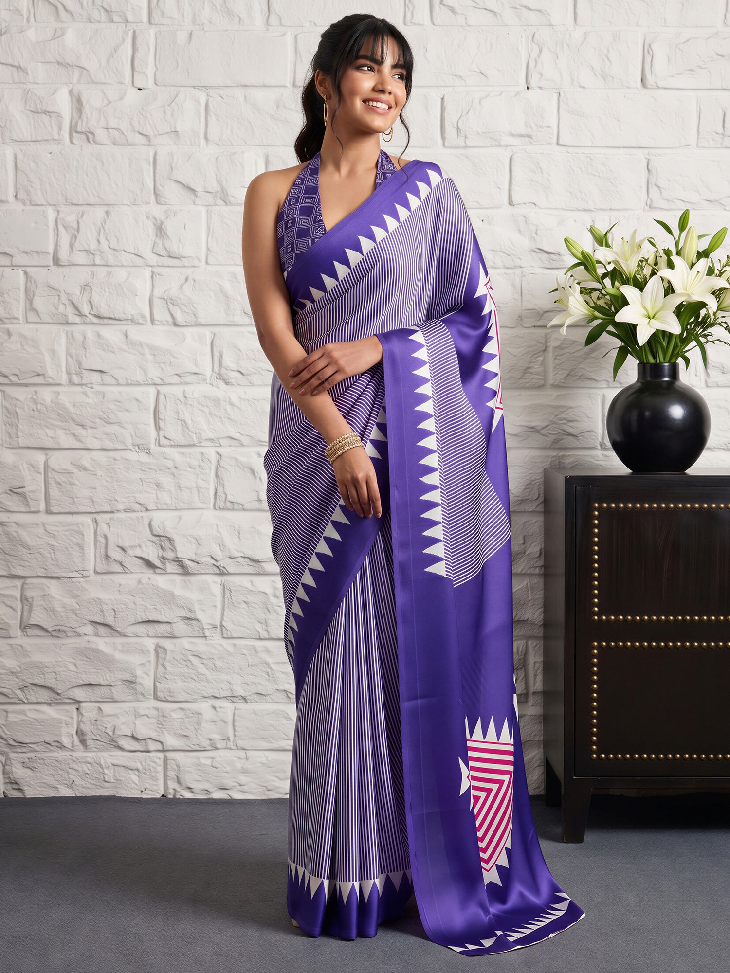 Woman wearing violet satin silk saree with striped pattern design and violet blouse
