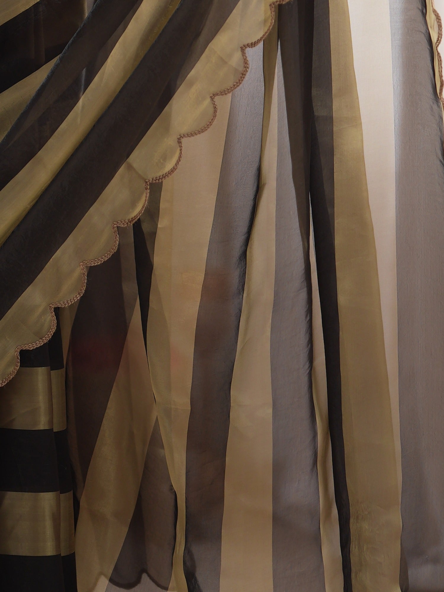 Pallu detail of black satin saree showing striped pattern design and embroidered border