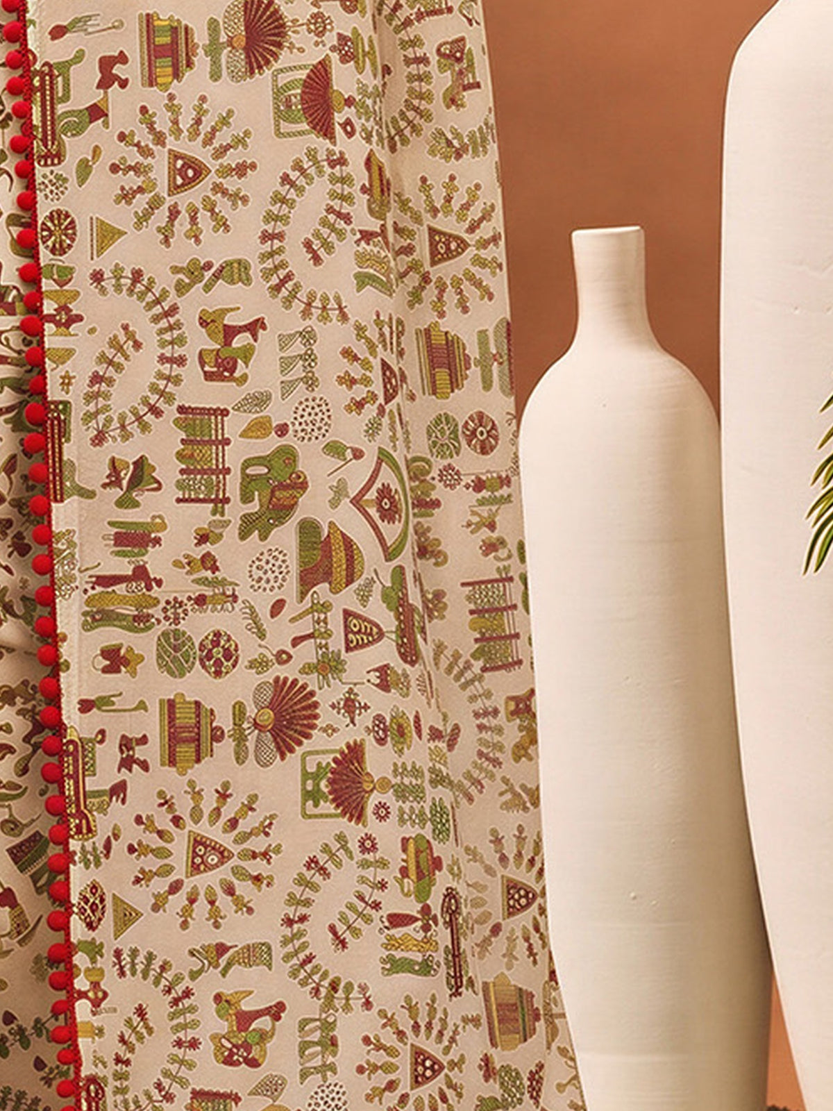 Pallu detail of beige georgette saree showing tribal folk-art motifs and embroidered border