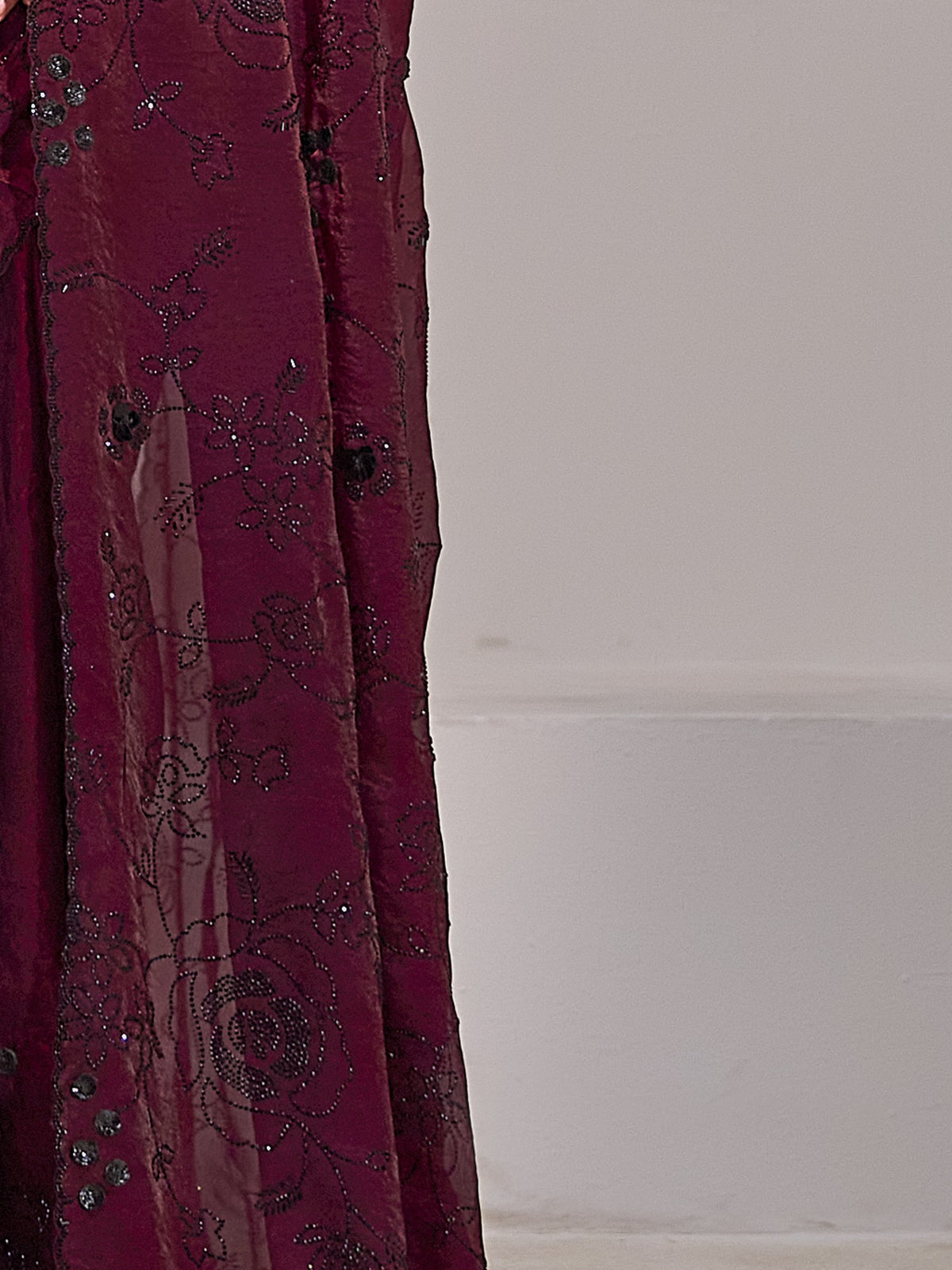 Pallu detail of maroon satin silk saree showing ornamented surface design and embellished border