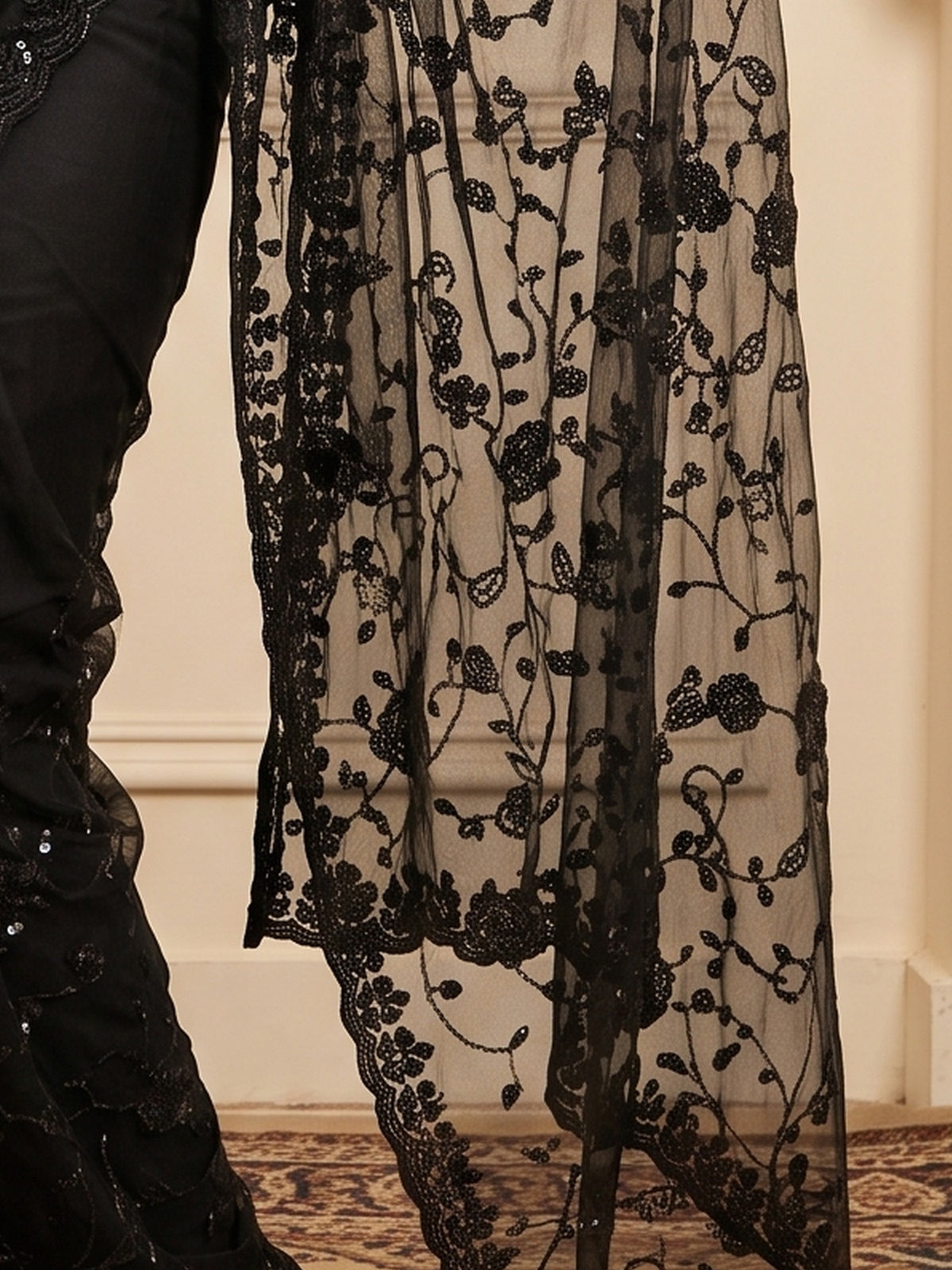 Pallu detail of black georgette saree showing ornamented surface design and embellished border