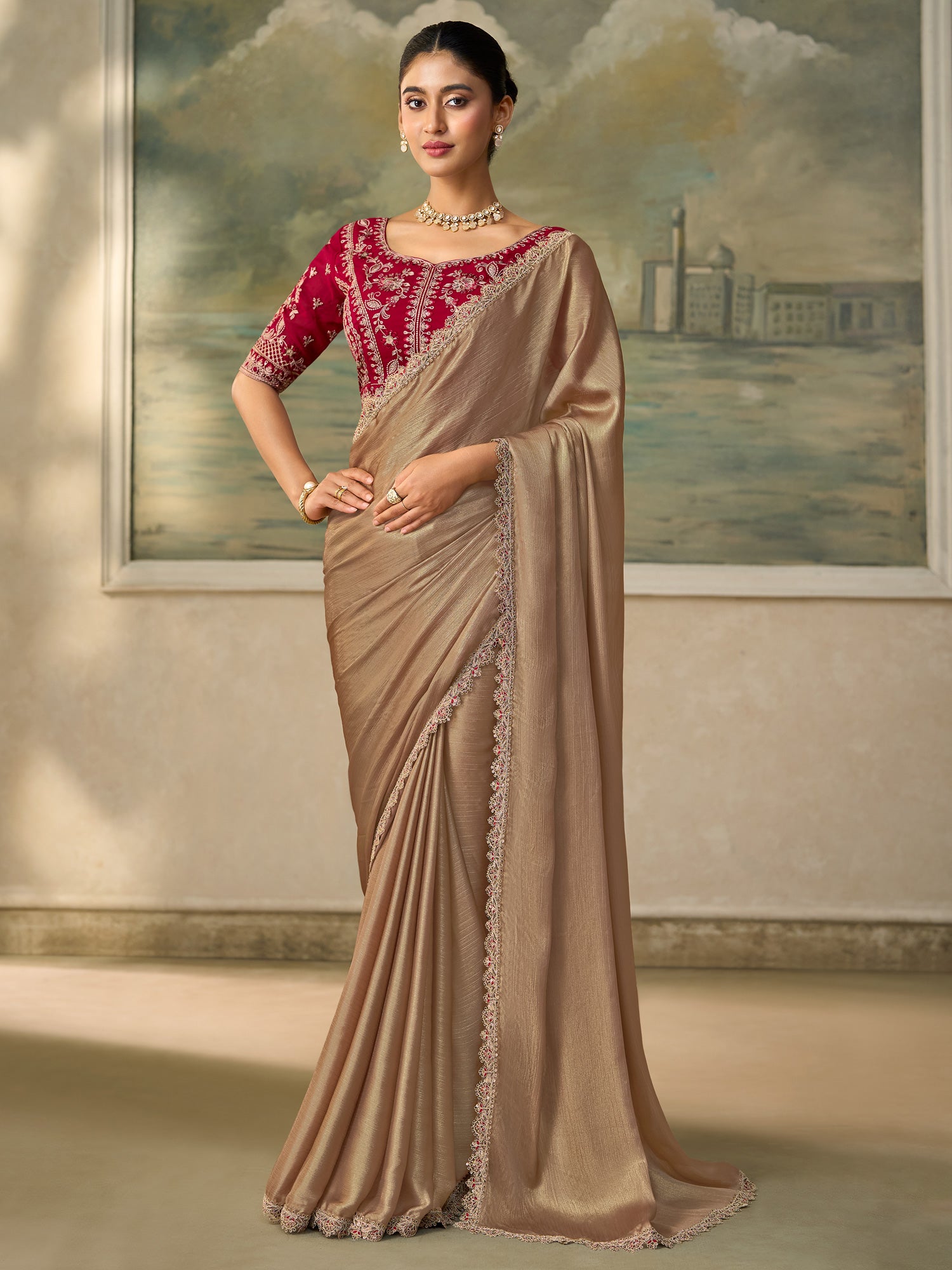 Woman wearing gold chiffon saree with embroidered motif work and red blouse