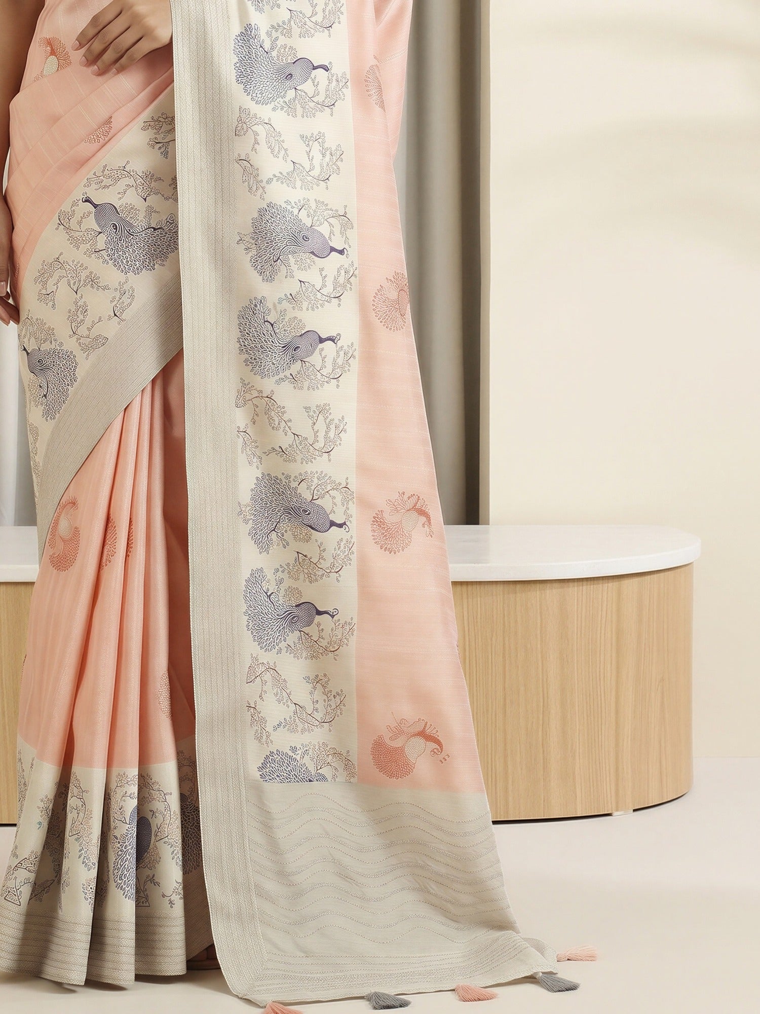 Pallu detail of peach silk blend saree showing peacock motif design and embroidered border