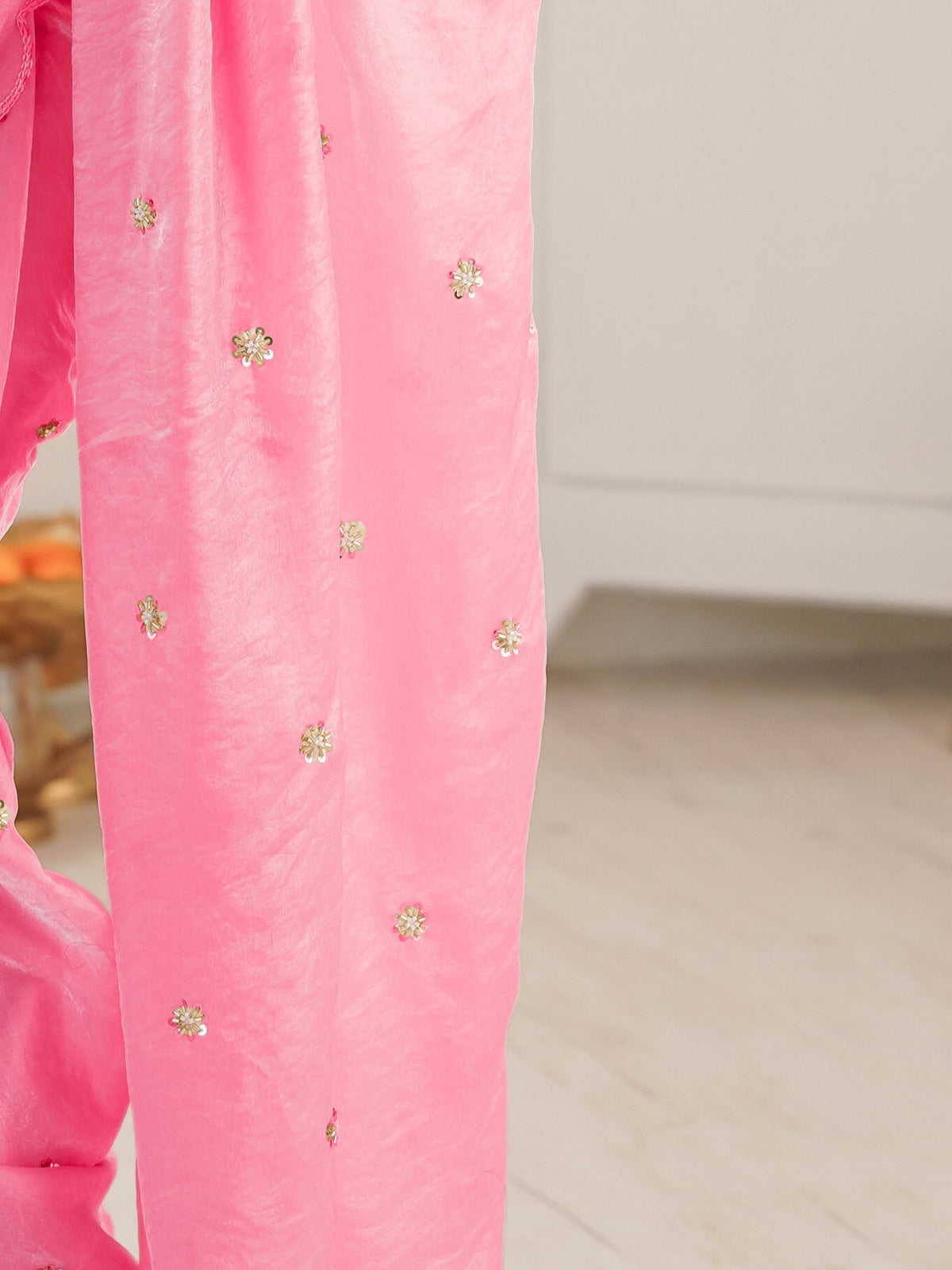 Pallu detail of pink satin saree showing ornamented surface design and embroidered border