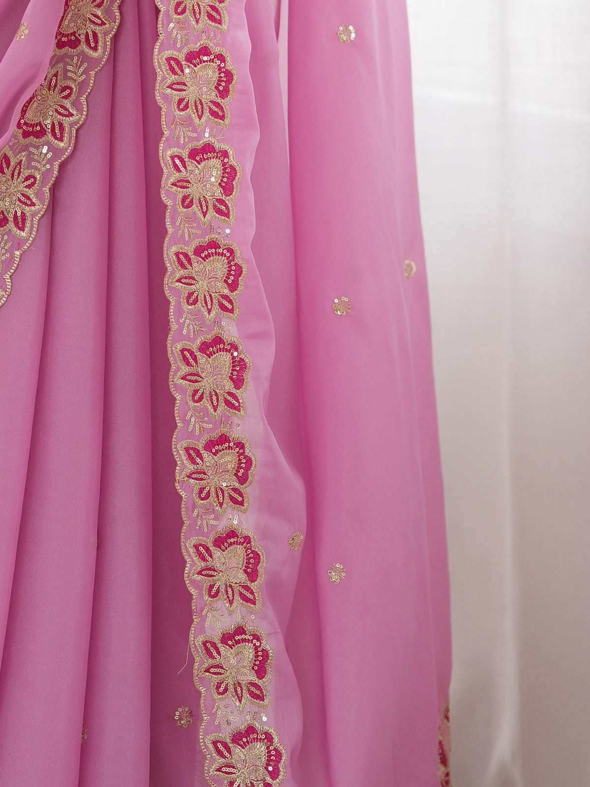 Pallu detail of pink georgette saree showing ornamented surface design and embellished border