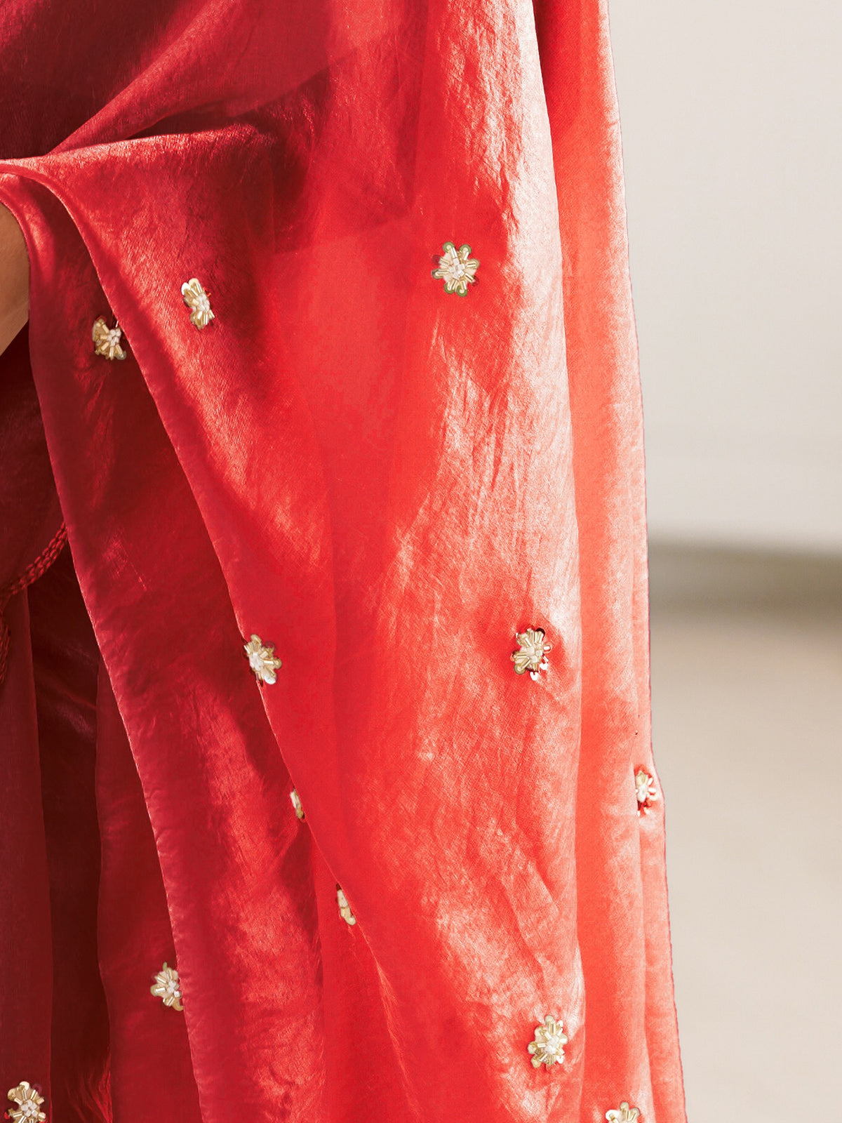 Pallu detail of maroon satin saree showing ornamented surface design and embroidered border