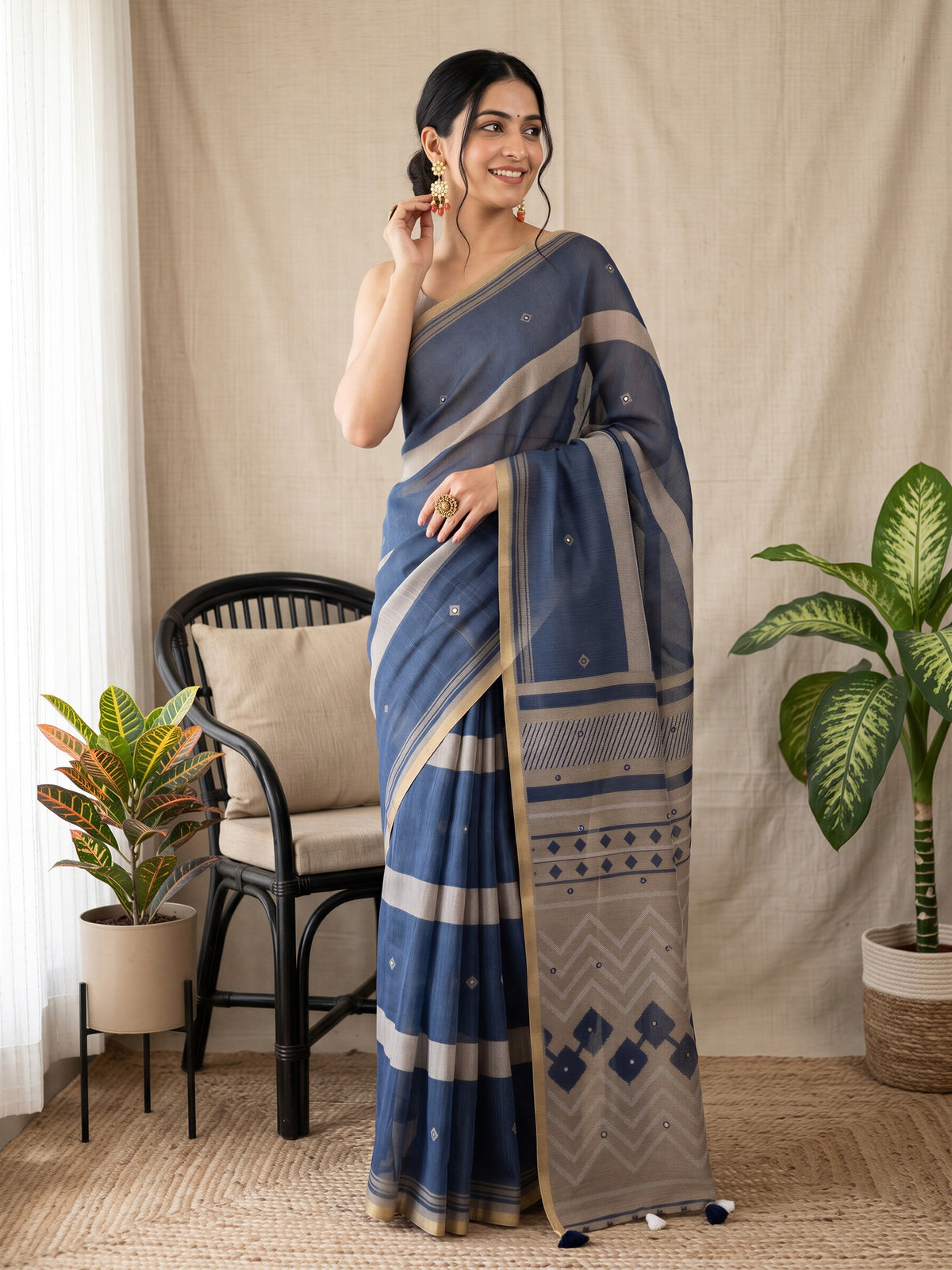 Woman wearing navy blue linen blend saree with traditional indian motif work and taupe blouse