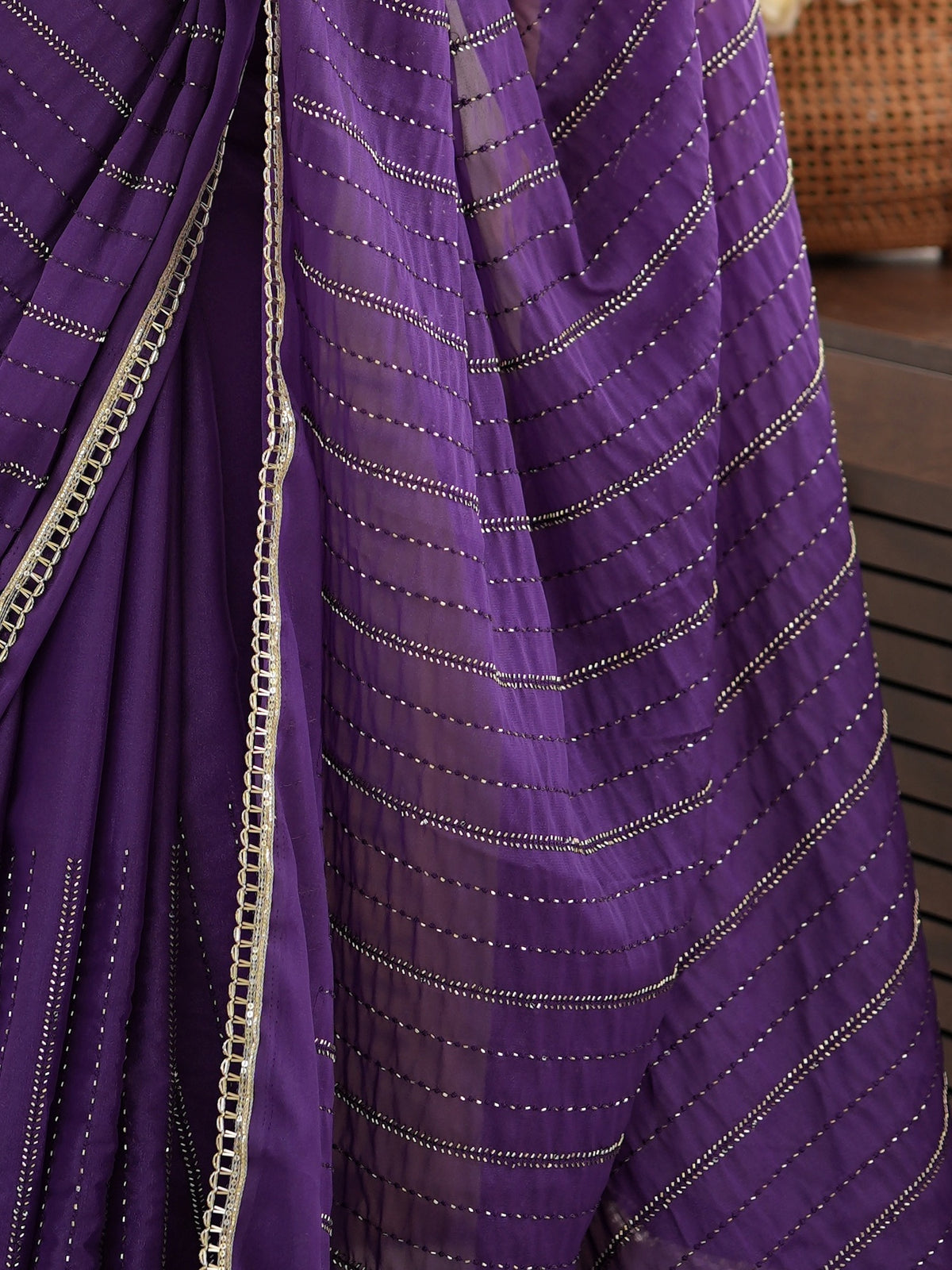 Pallu detail of violet georgette saree showing ornamented surface design and embellished border