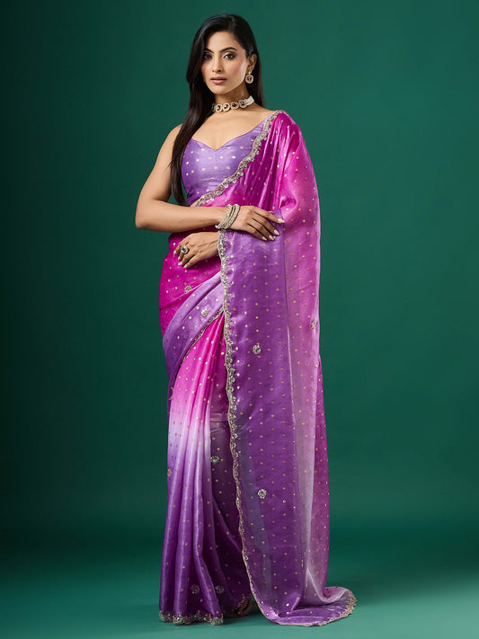 Woman wearing lavender satin saree with ornamented surface design and lavender blouse