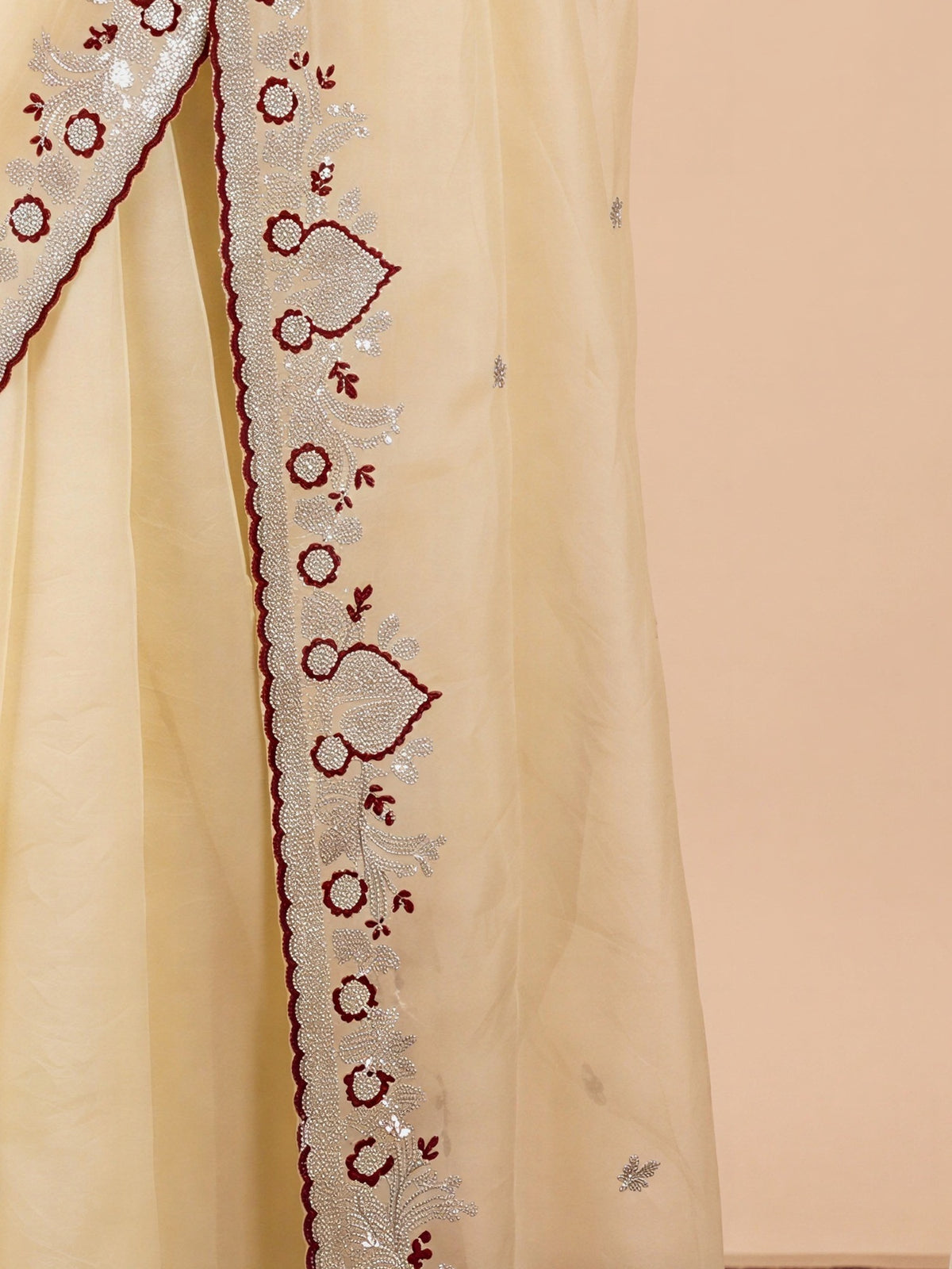 Pallu detail of off white tissue saree showing embroidered motif work and embellished border