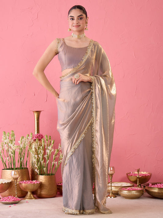 Woman wearing metallic paper silk ready to wear saree with ornamented surface design and metallic blouse