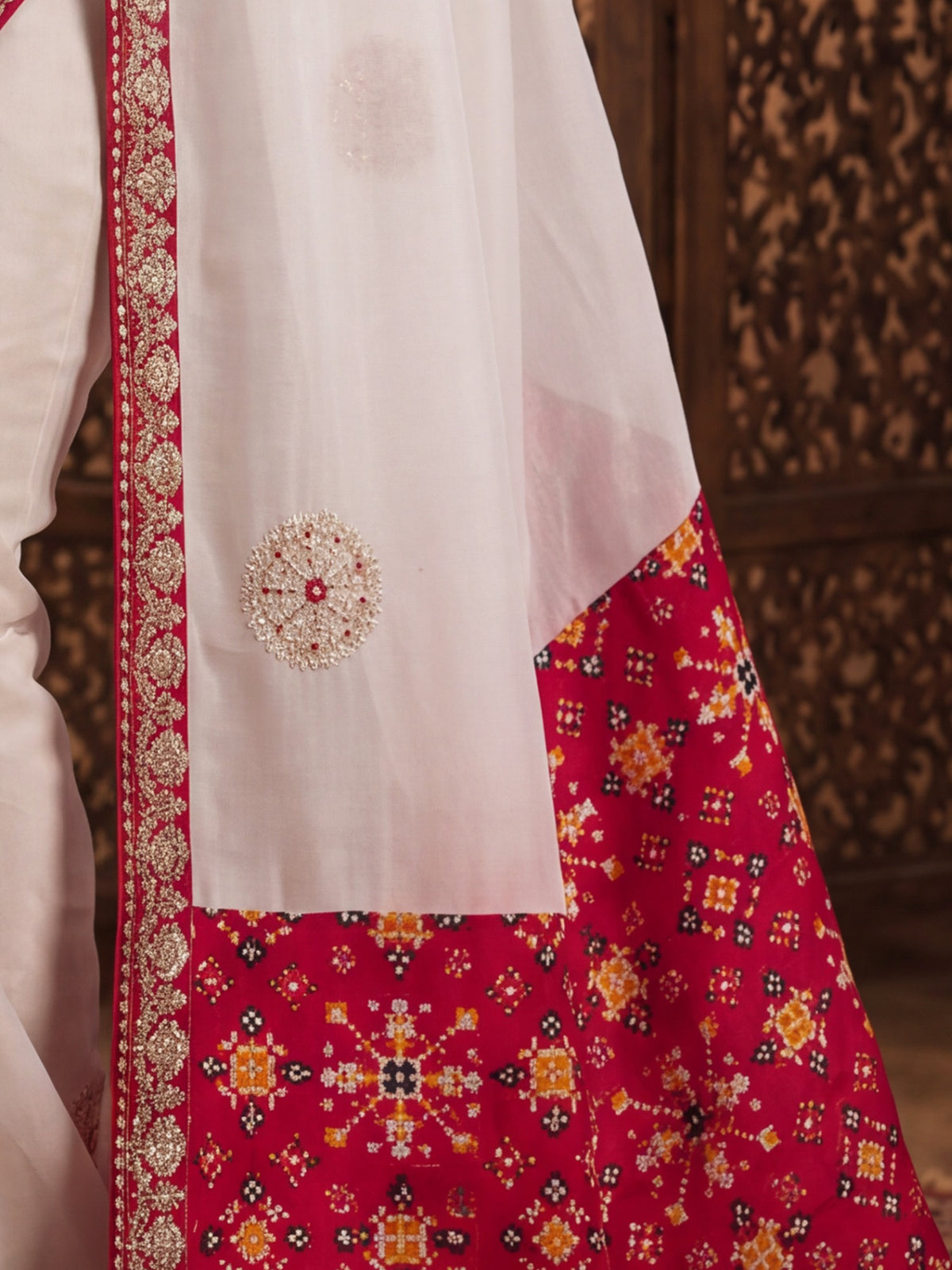 Pallu detail of white viscose saree showing zari butta (metallic motif) work and embellished border