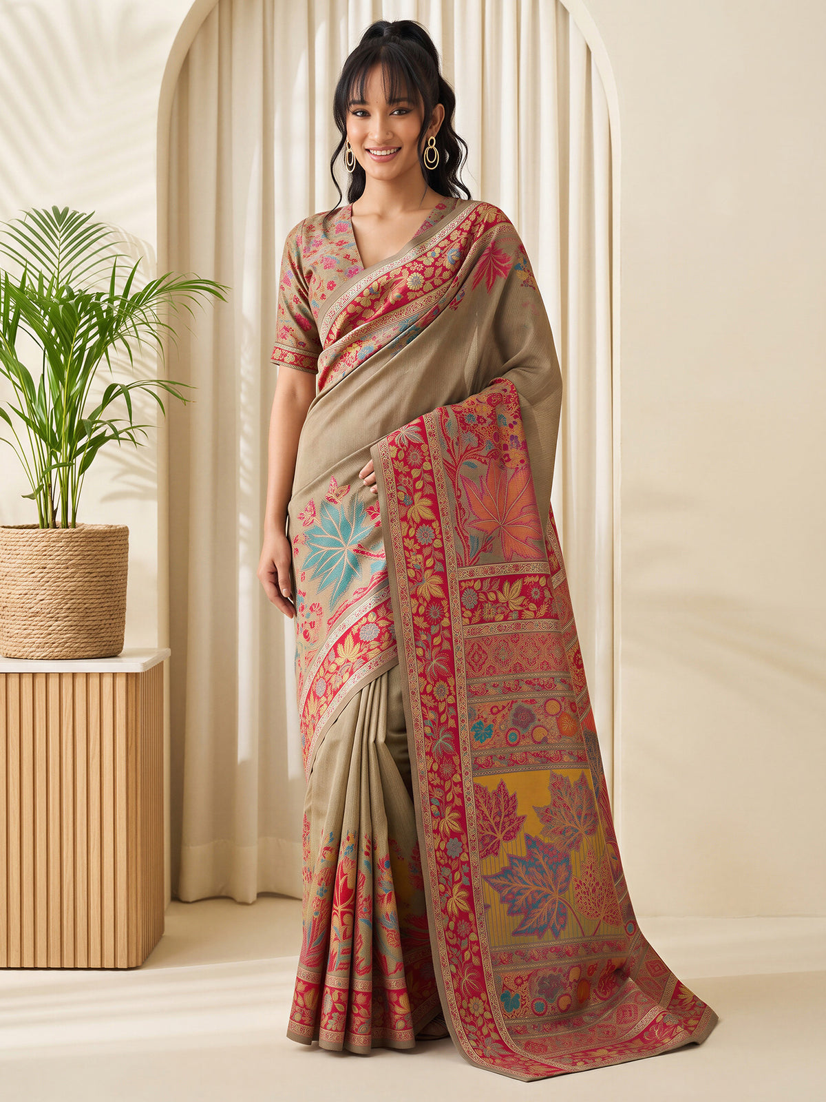 Woman wearing beige pashmina silk saree with traditional indian motif work and beige blouse