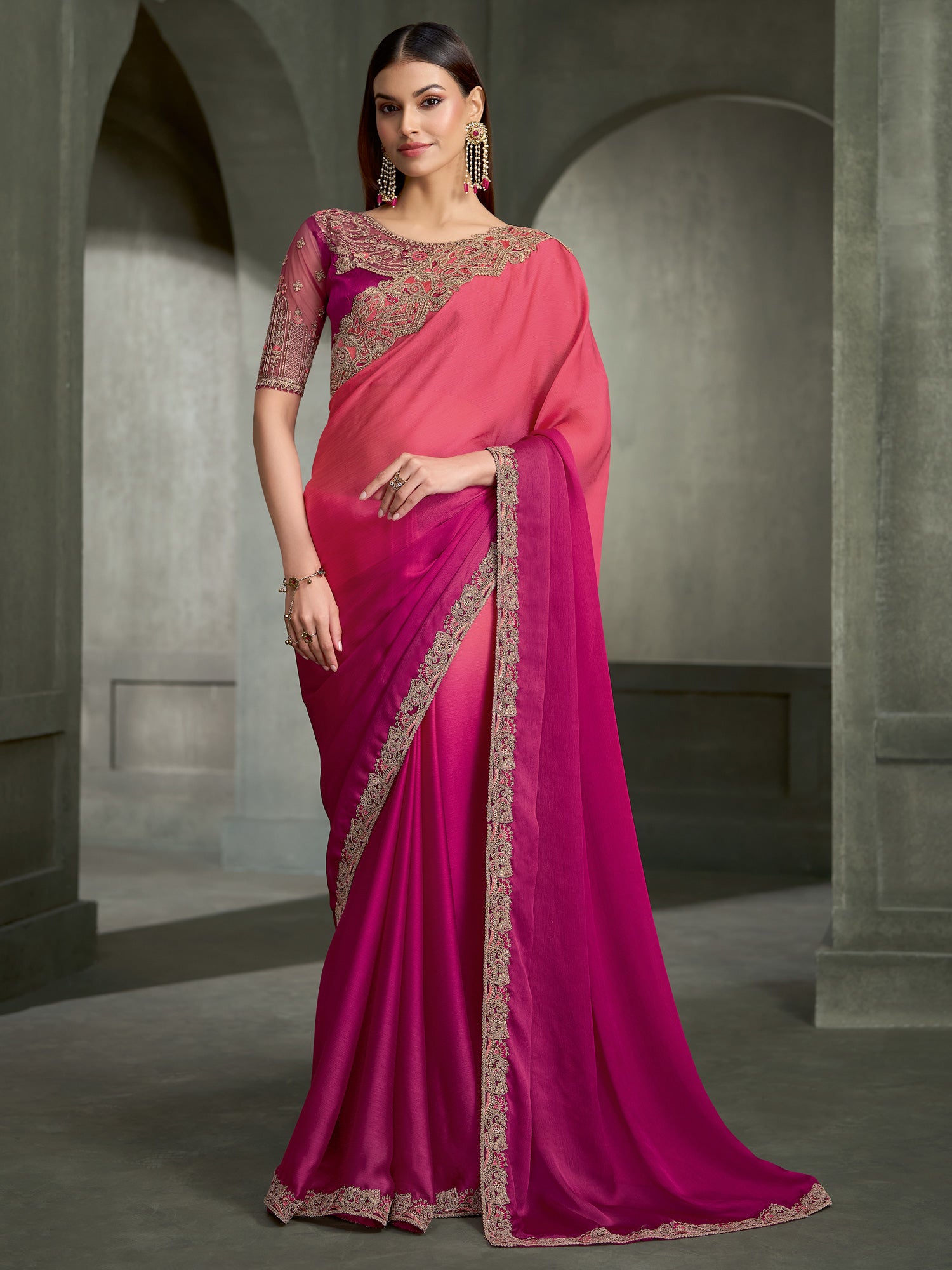 Woman wearing pink chiffon saree with embroidered motif work and magenta blouse