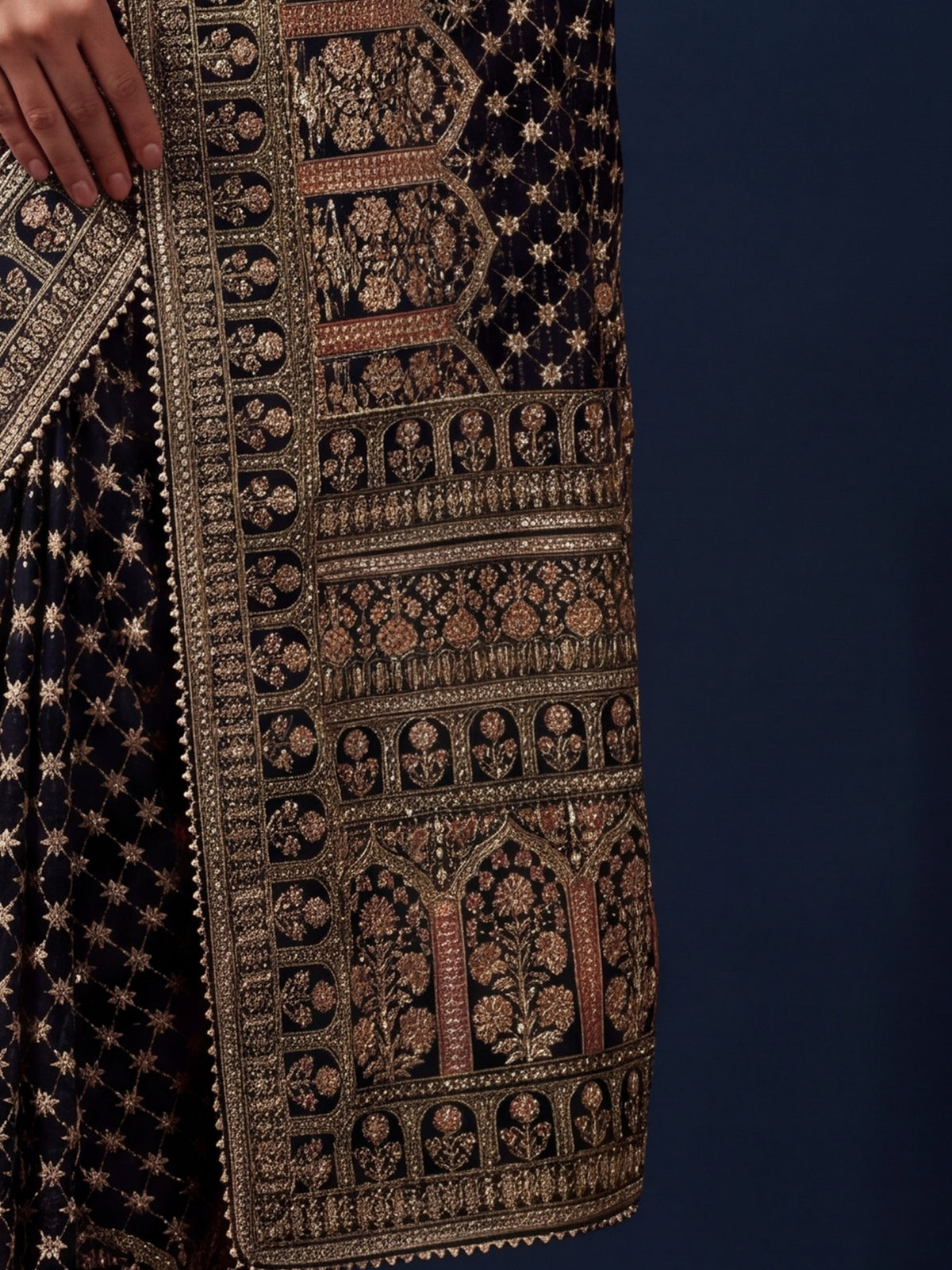Pallu detail of black silk blend saree showing traditional indian motif work and embellished border