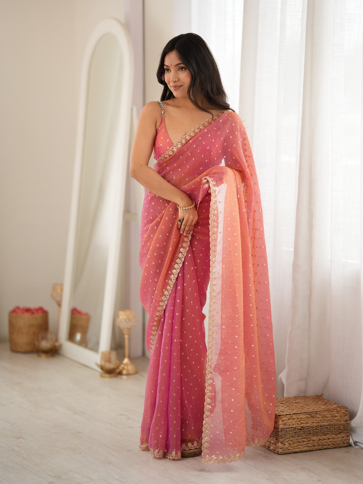 Woman wearing pink georgette saree with zari butta (metallic motif) work and pink blouse