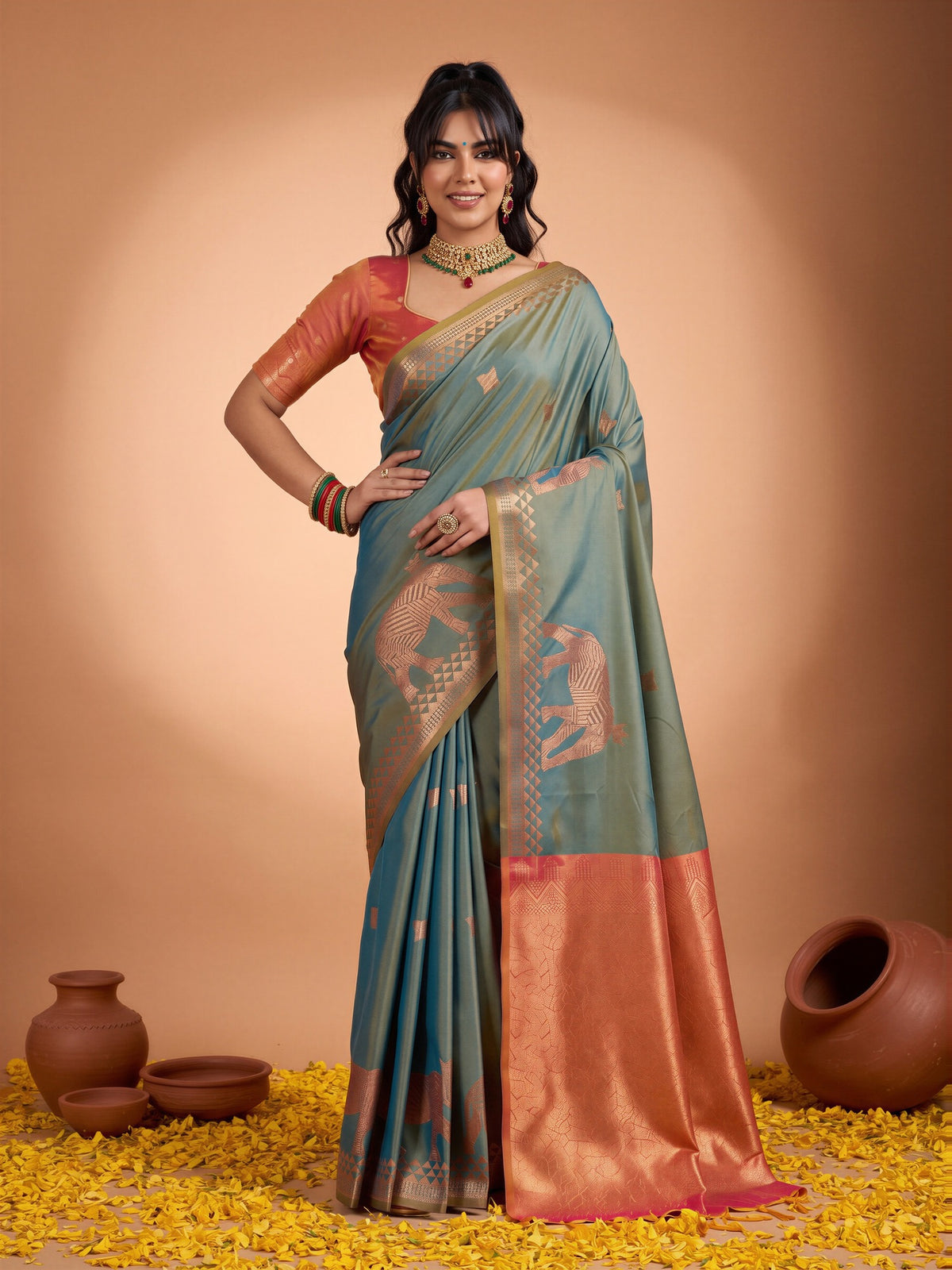 Woman wearing teal blue silk saree with animal-print design and rust blouse
