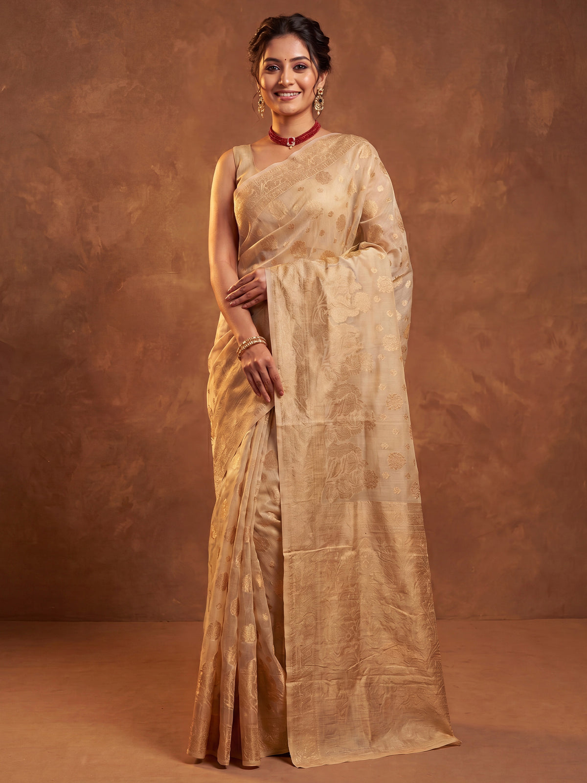 Woman wearing cream silk blend saree with zari butta (metallic motif) work and cream blouse