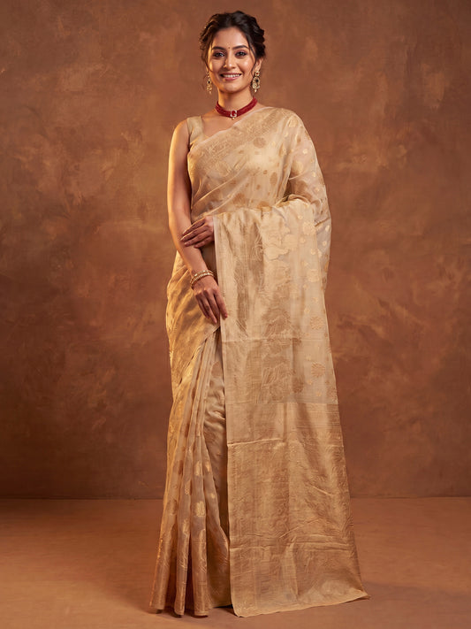 Woman wearing cream silk blend saree with zari butta (metallic motif) work and cream blouse
