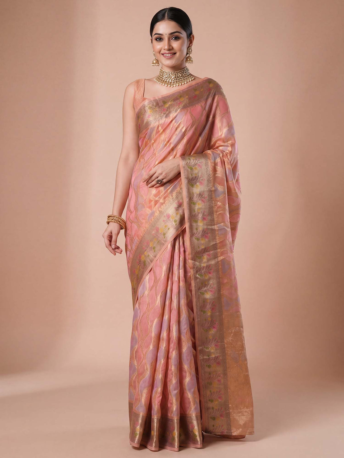 Woman wearing pink organza saree with traditional indian motif work and pink blouse