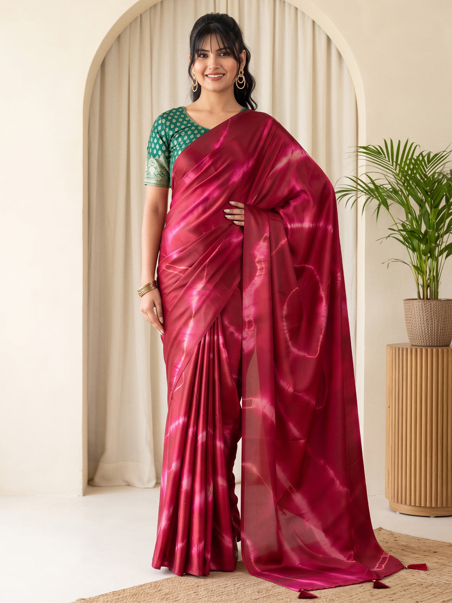 Woman wearing maroon satin silk saree with tie-and-dye resist pattern and green blouse