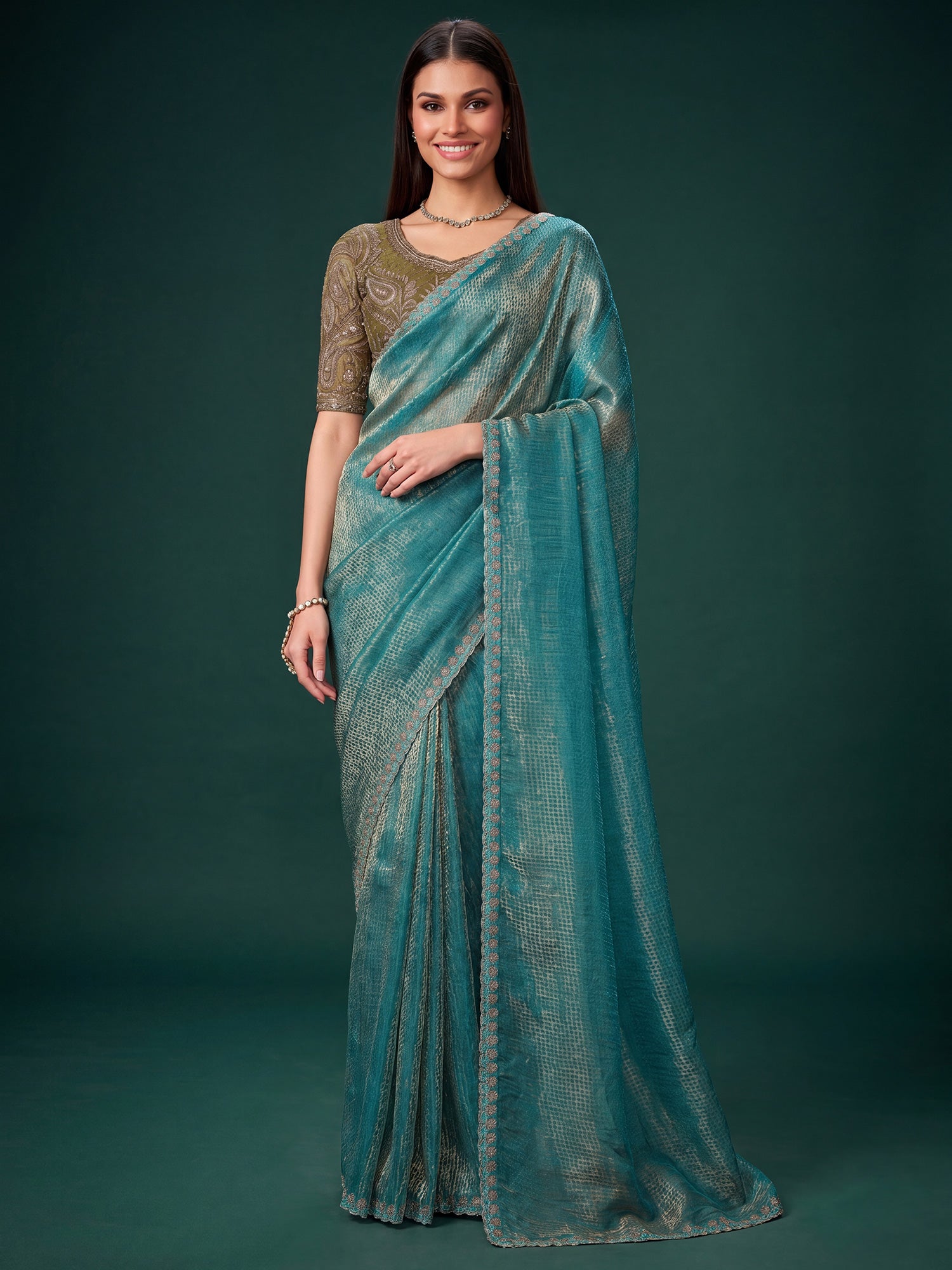 Woman wearing light blue georgette saree with ornamented surface design and green blouse
