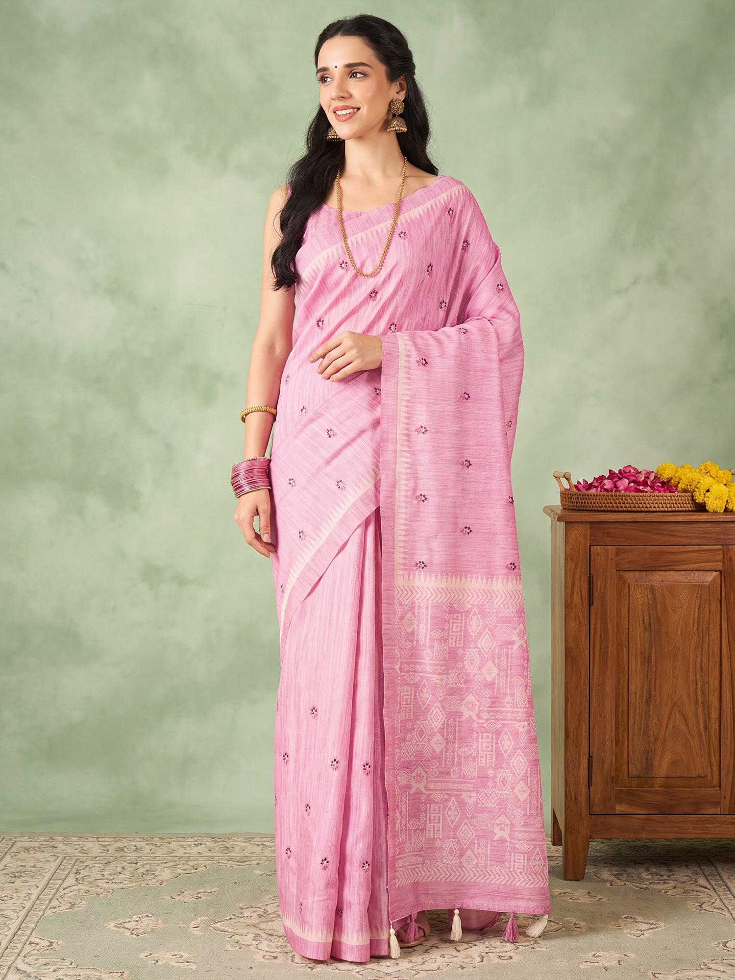 Woman wearing pink silk blend saree with embroidered motif work and pink blouse