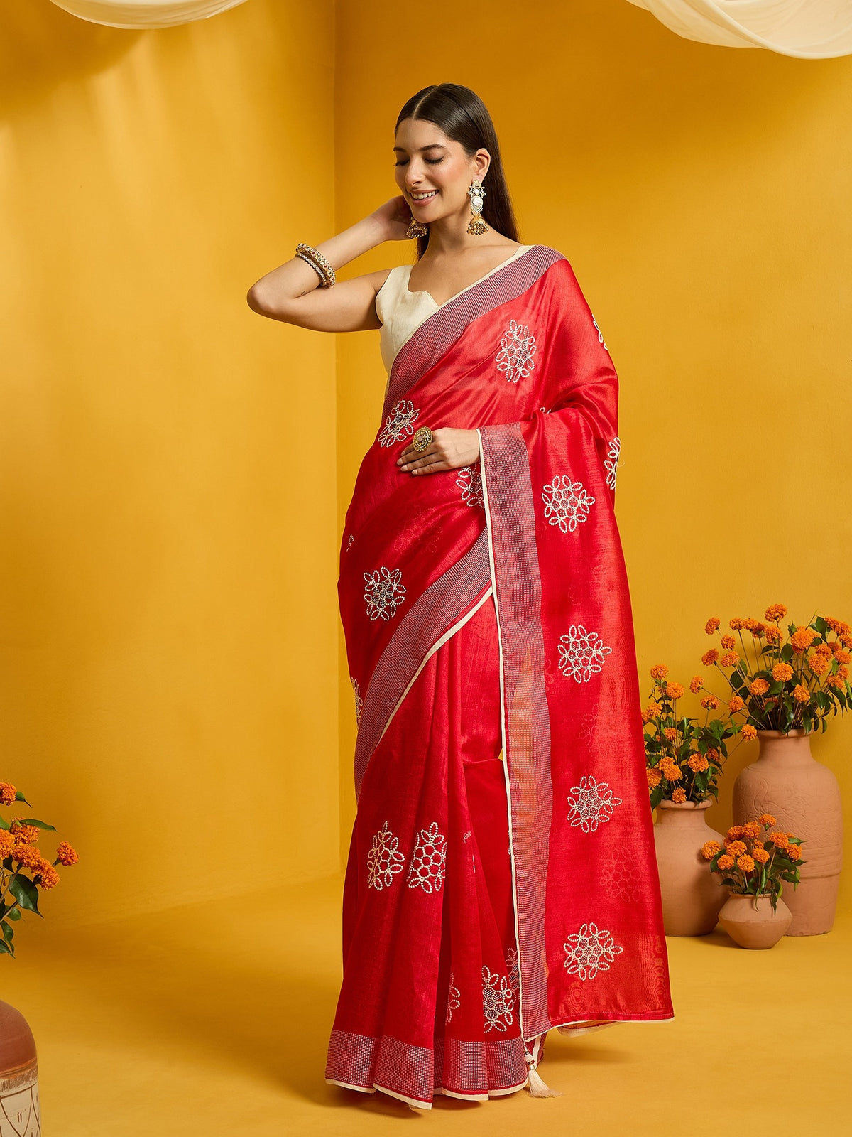 Woman wearing red cotton blend saree with embroidered motif work and cream blouse