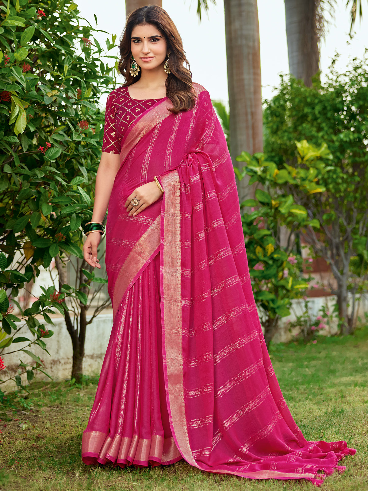 Woman wearing pink georgette saree with striped pattern design and pink blouse