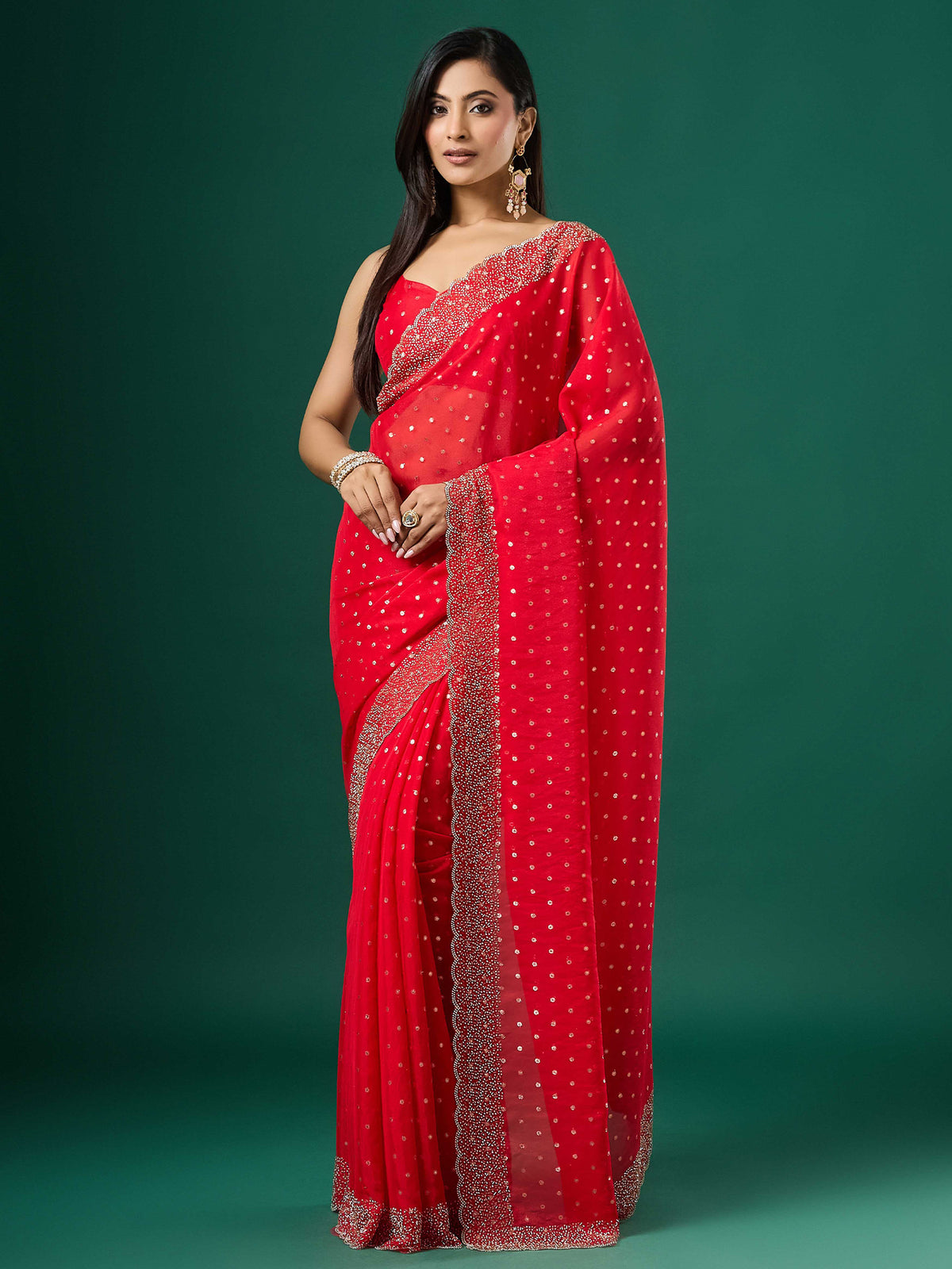 Woman wearing red silk blend saree with ornamented surface design and red blouse