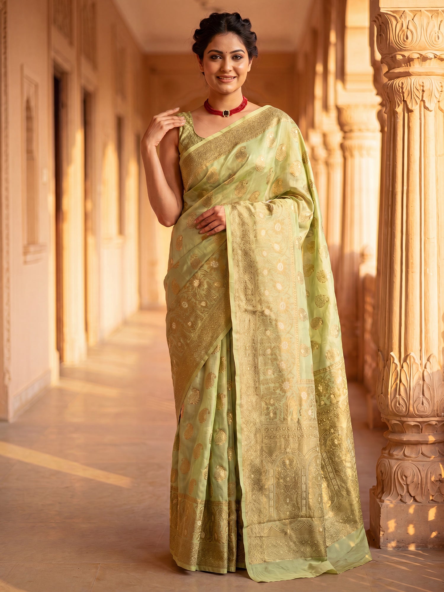 Woman wearing light green silk blend saree with zari butta (metallic motif) work and light green blouse