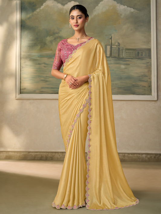 Woman wearing yellow chiffon saree with embroidered motif work and pink blouse