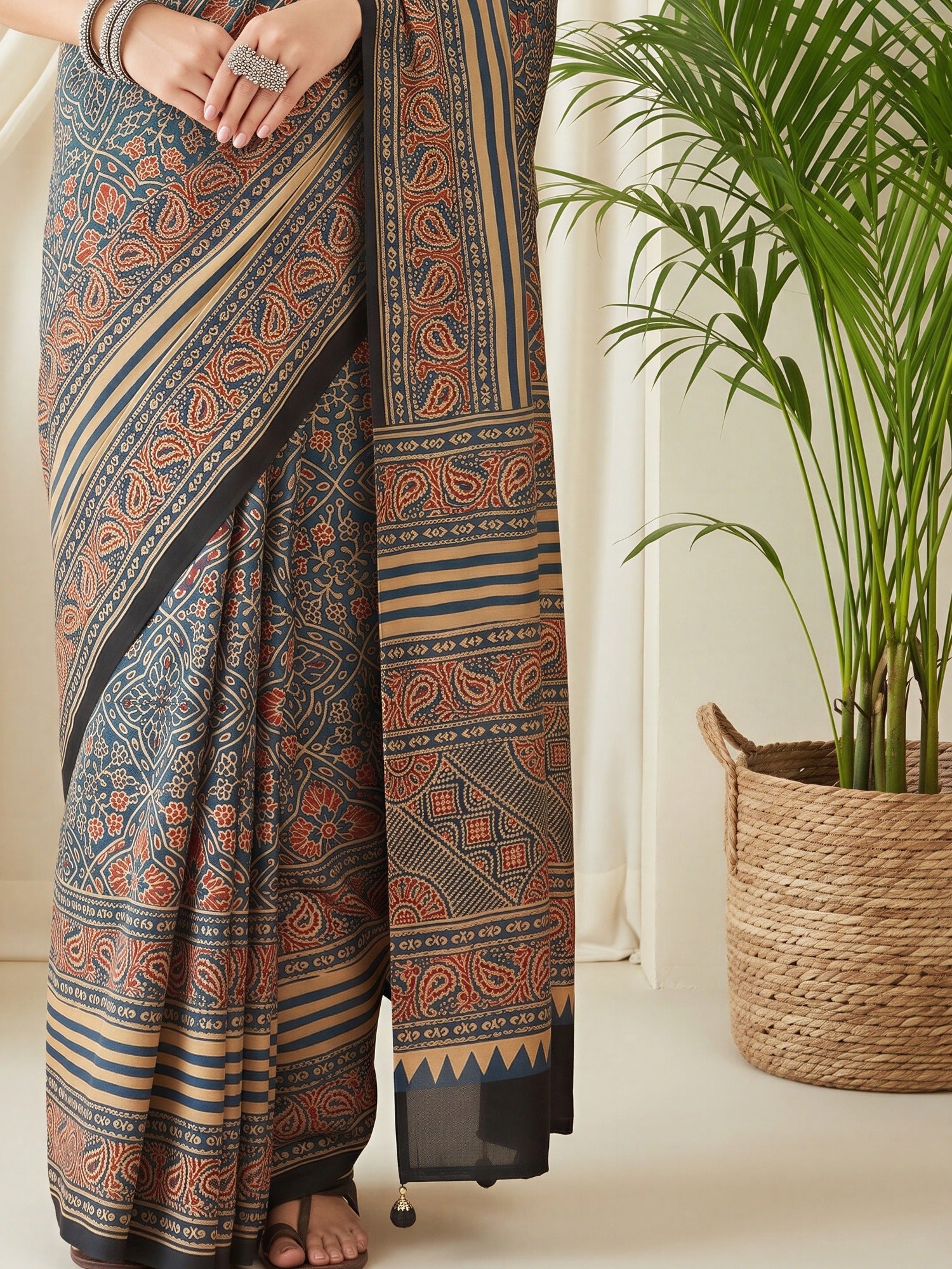 Pallu detail of teal blue silk blend saree showing traditional indian motif work and printed border