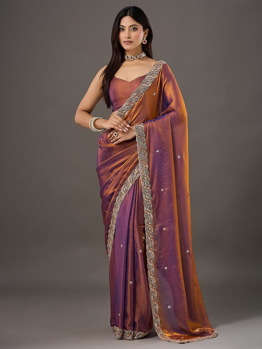 Woman wearing bronze satin saree with ornamented surface design and bronze blouse