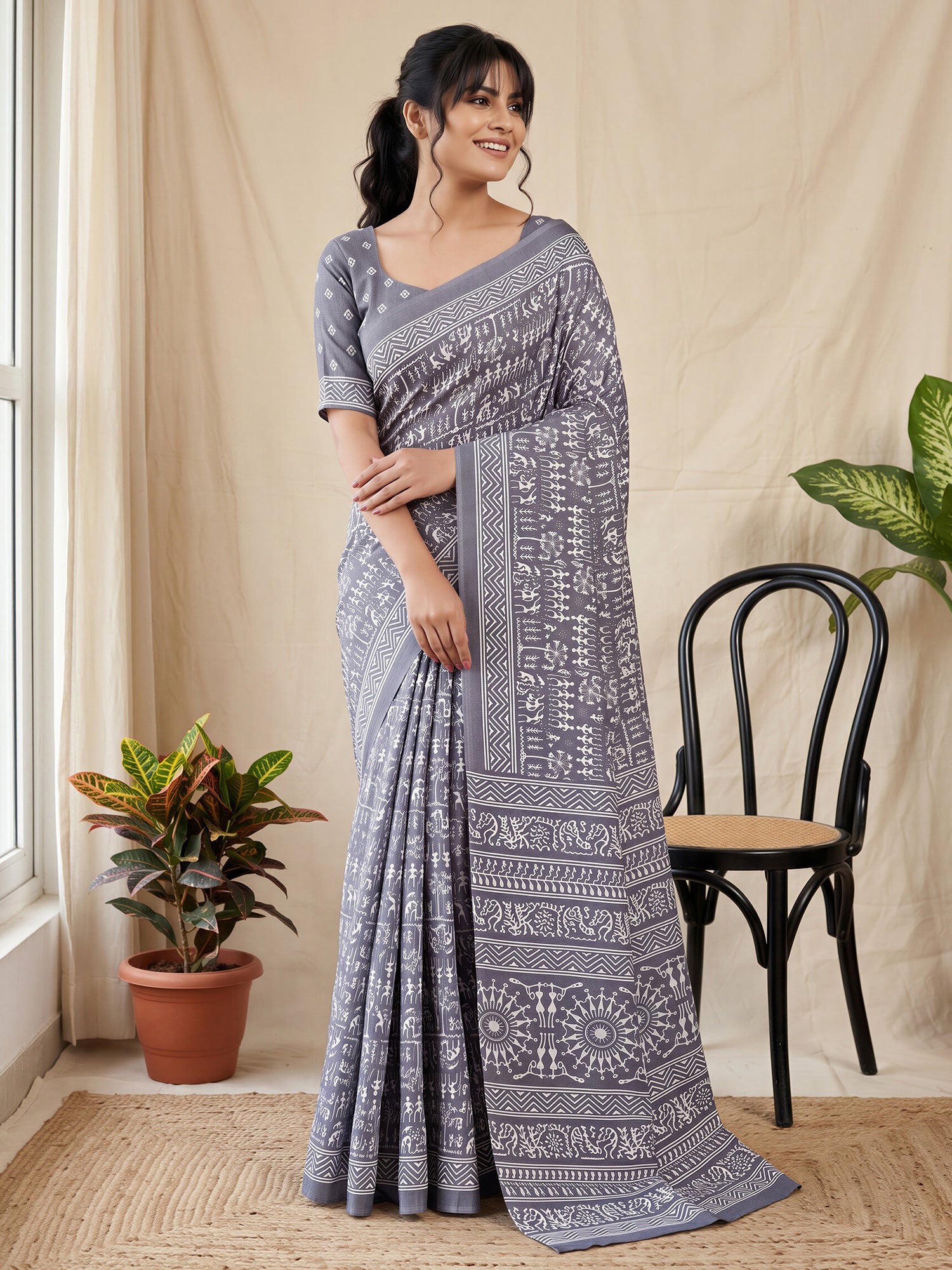 Woman wearing grey dola silk saree with warli folk-art figures and grey blouse