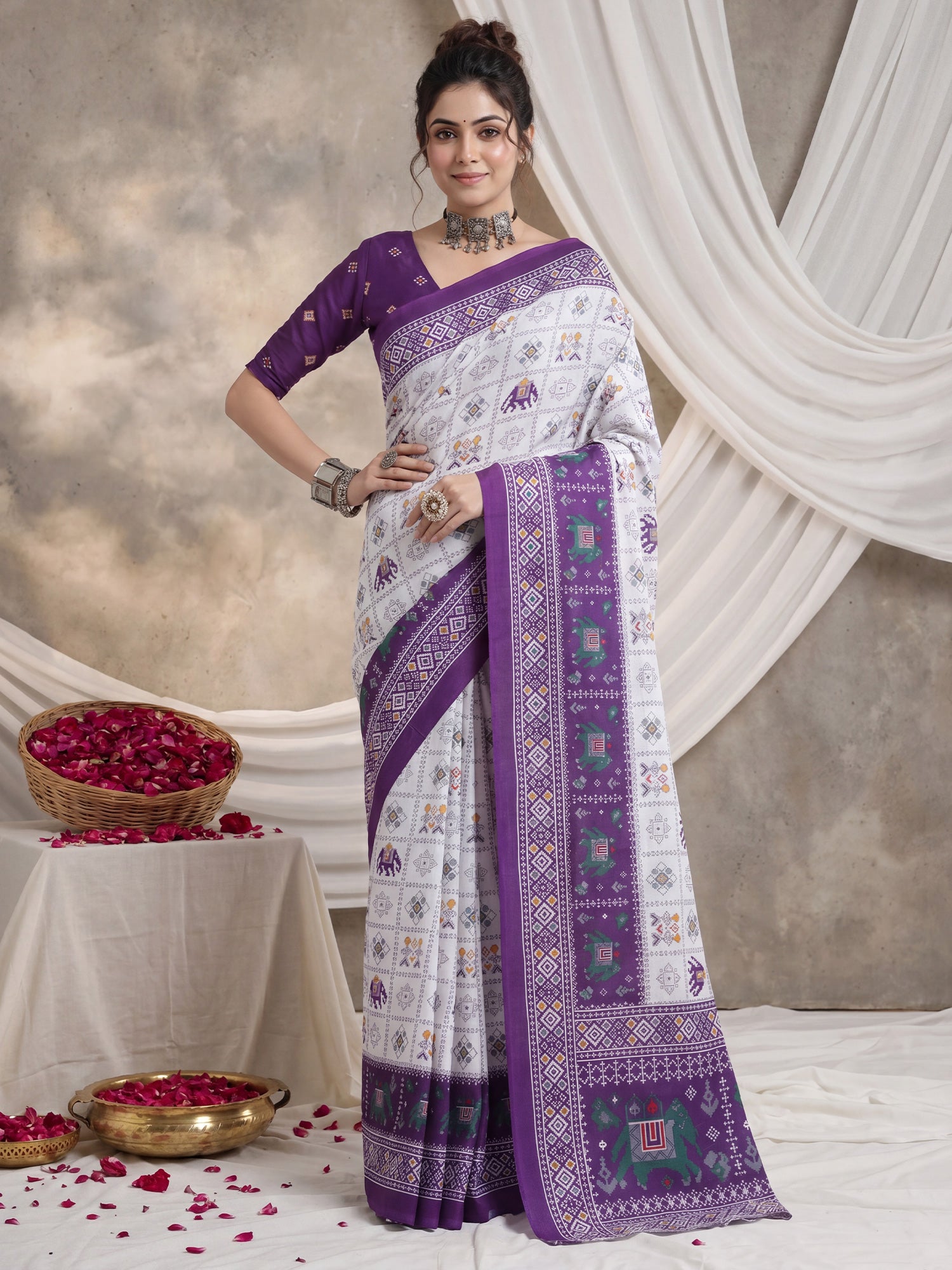 Woman wearing white cotton saree with traditional indian motif work and purple blouse
