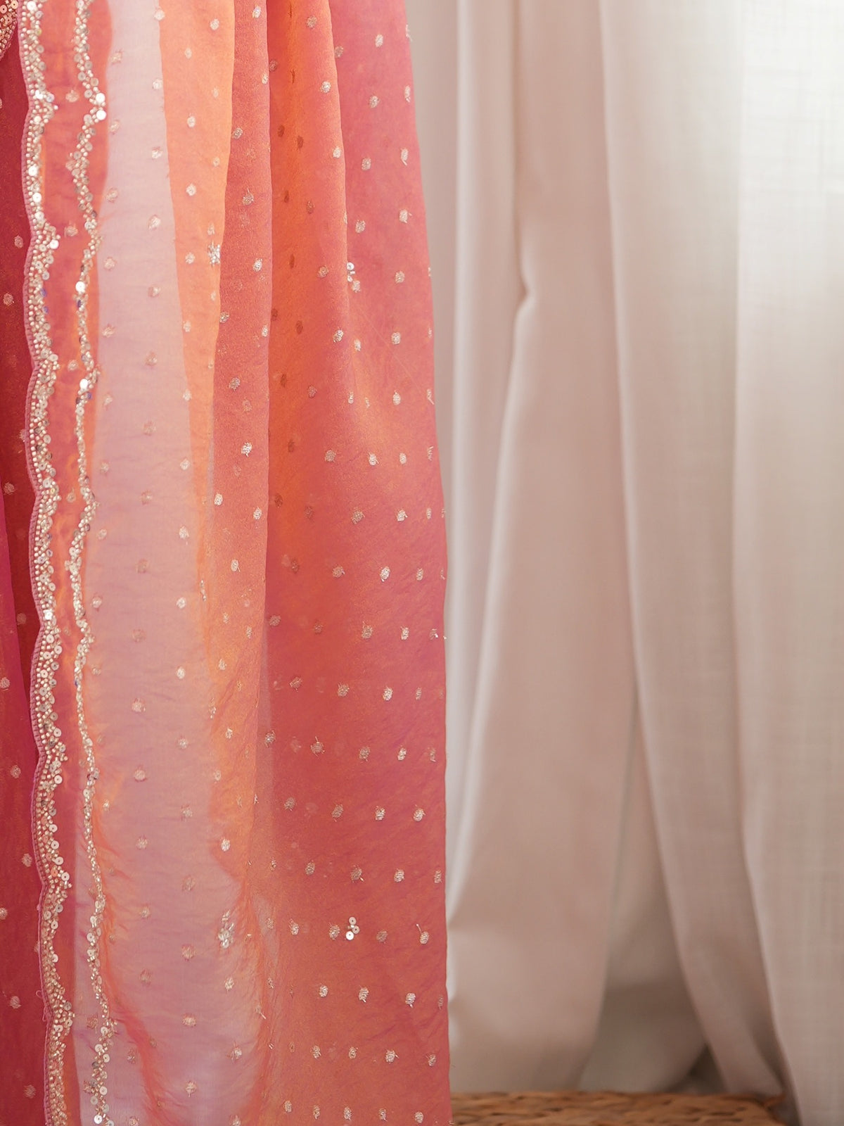 Pallu detail of pink georgette saree showing zari butta (metallic motif) work and embellished border