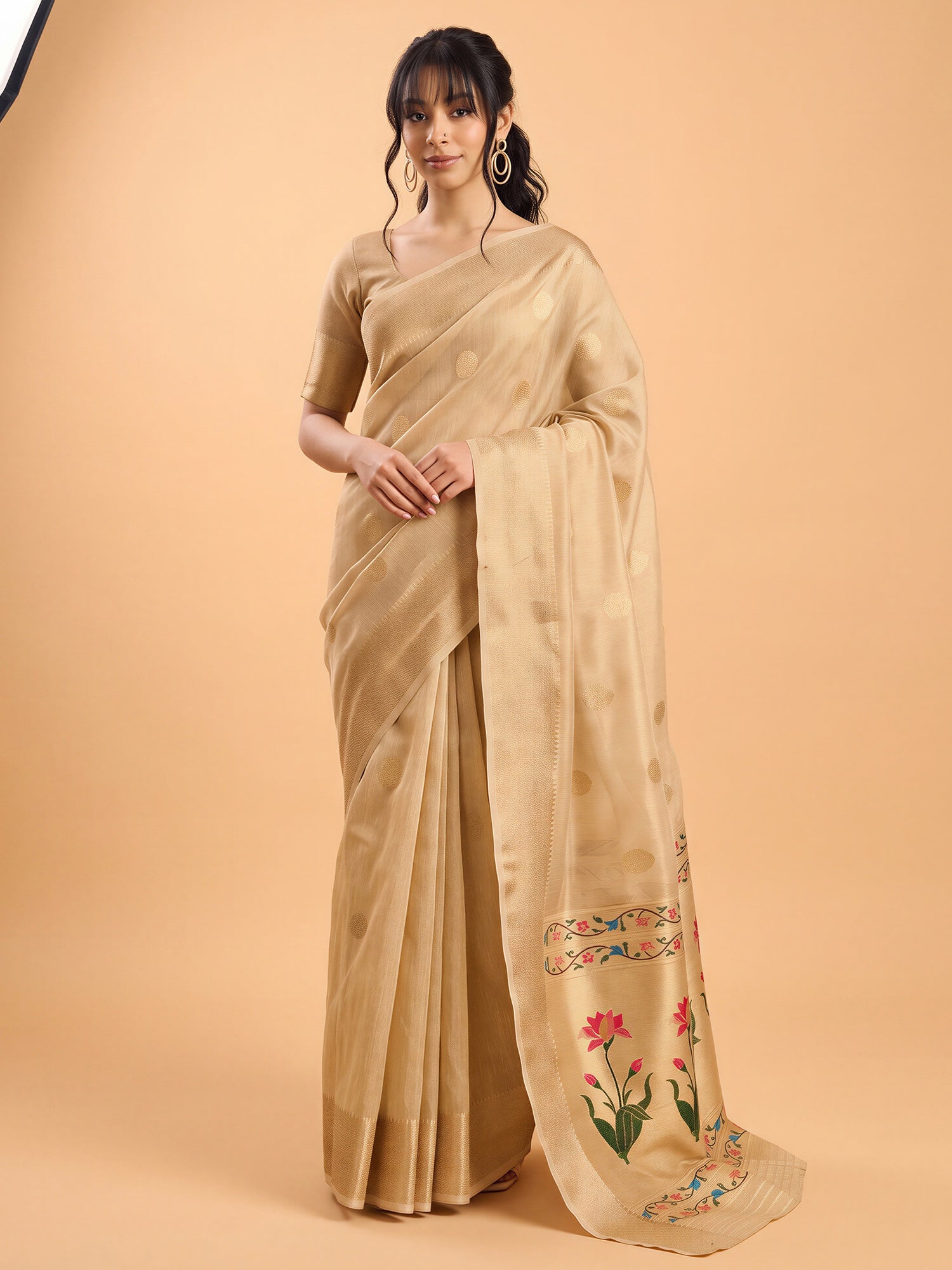 Woman wearing cream tissue saree with zari butta (metallic motif) work and cream blouse