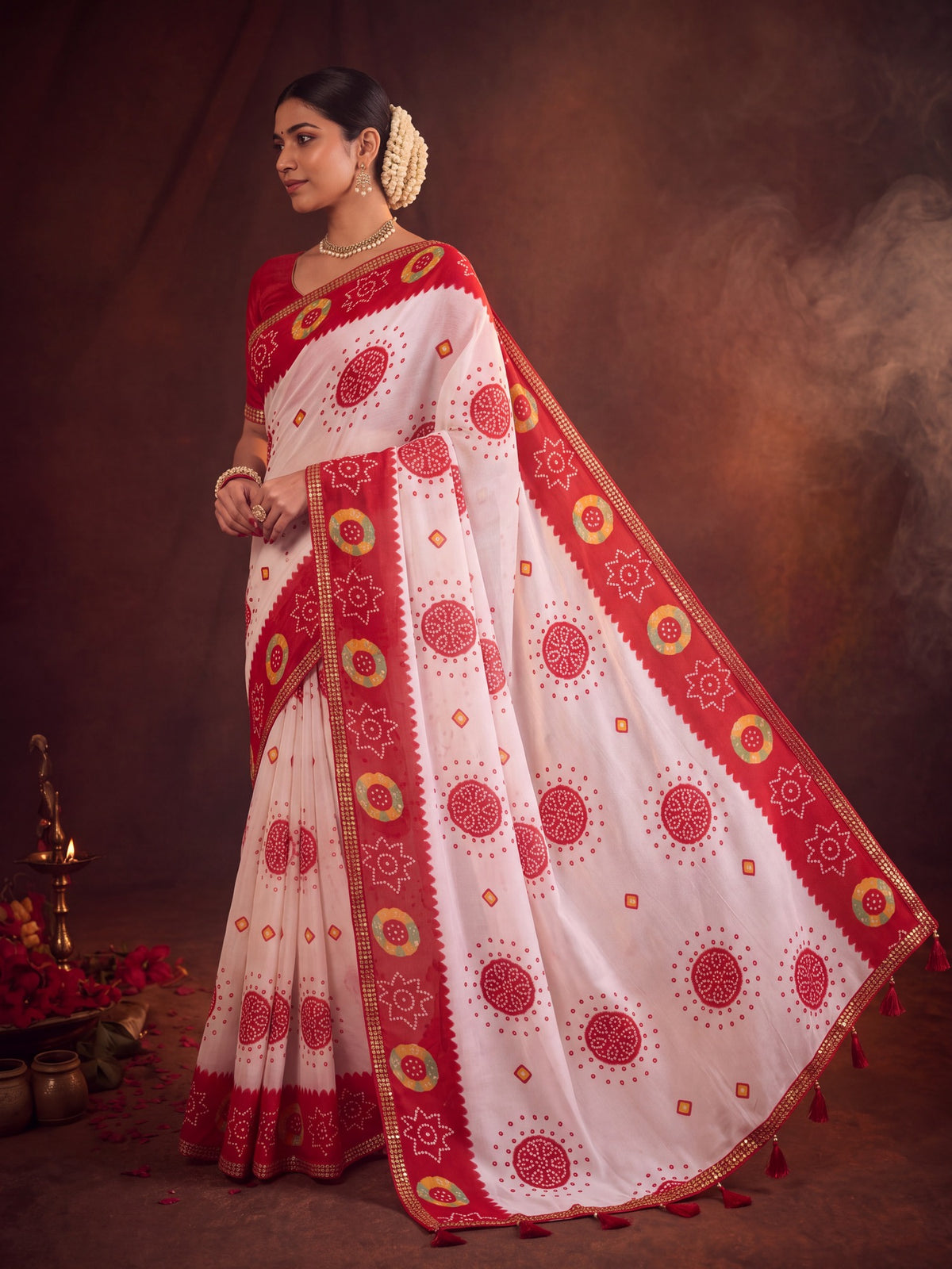 Woman wearing white georgette saree with bandhani tie-dye dot work and red blouse