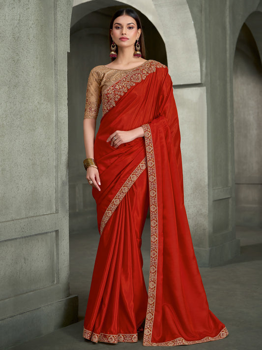Woman wearing orange crepe saree with embroidered motif work and beige blouse