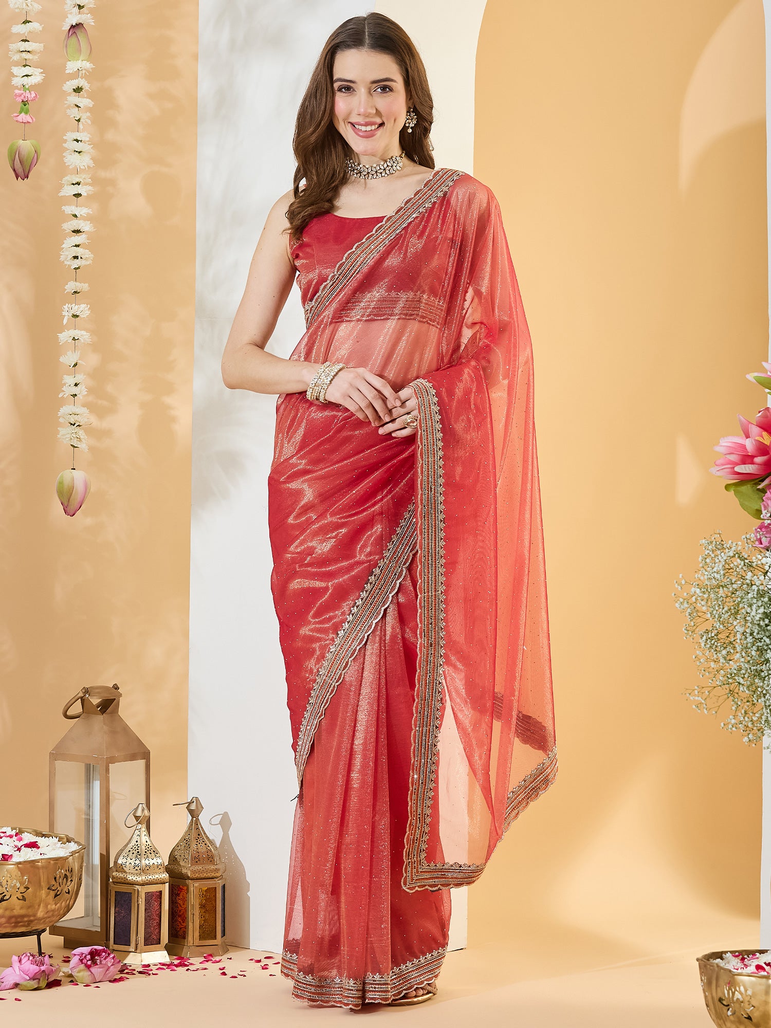 Woman wearing orange net saree with ornamented surface design and orange blouse