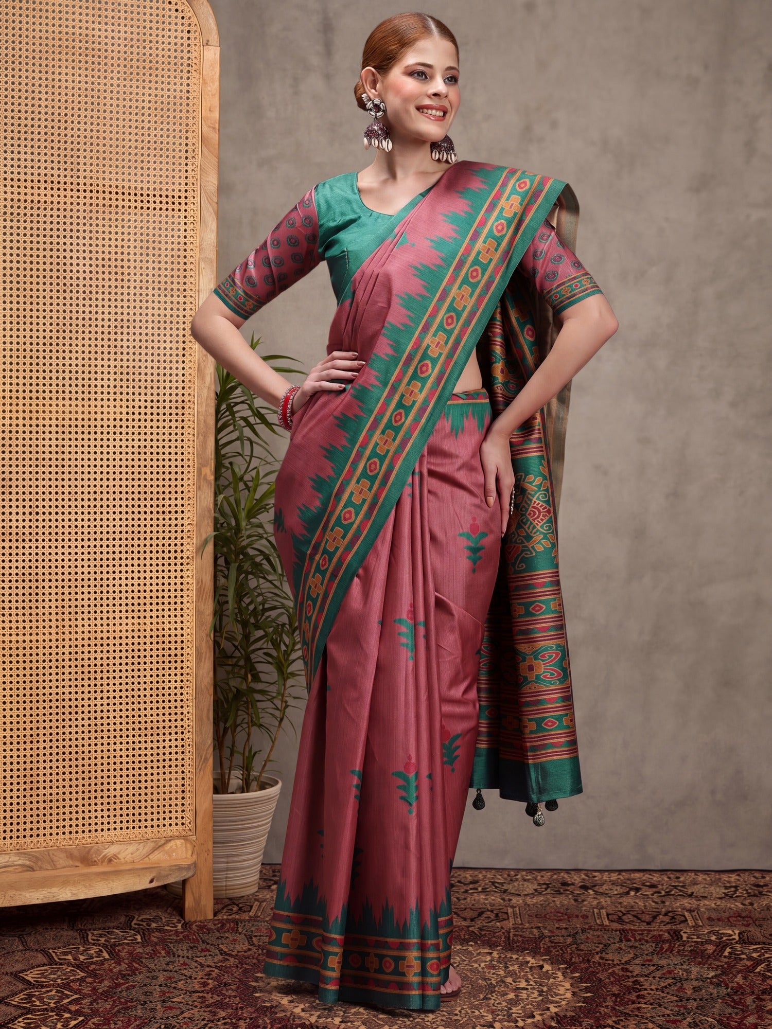 Woman wearing mauve silk blend saree with traditional indian motif work and teal green blouse