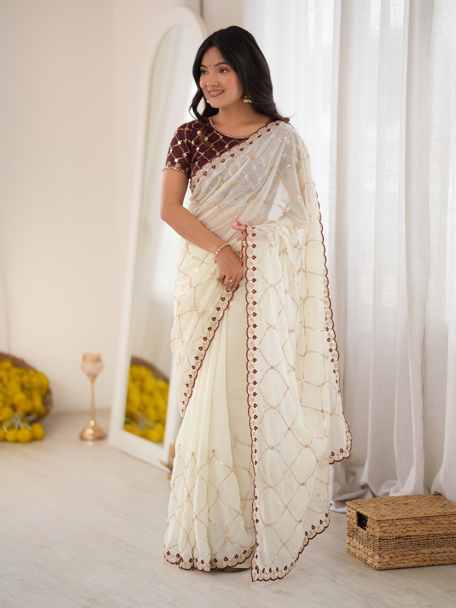 Woman wearing off white georgette saree with ornamented surface design and brown blouse