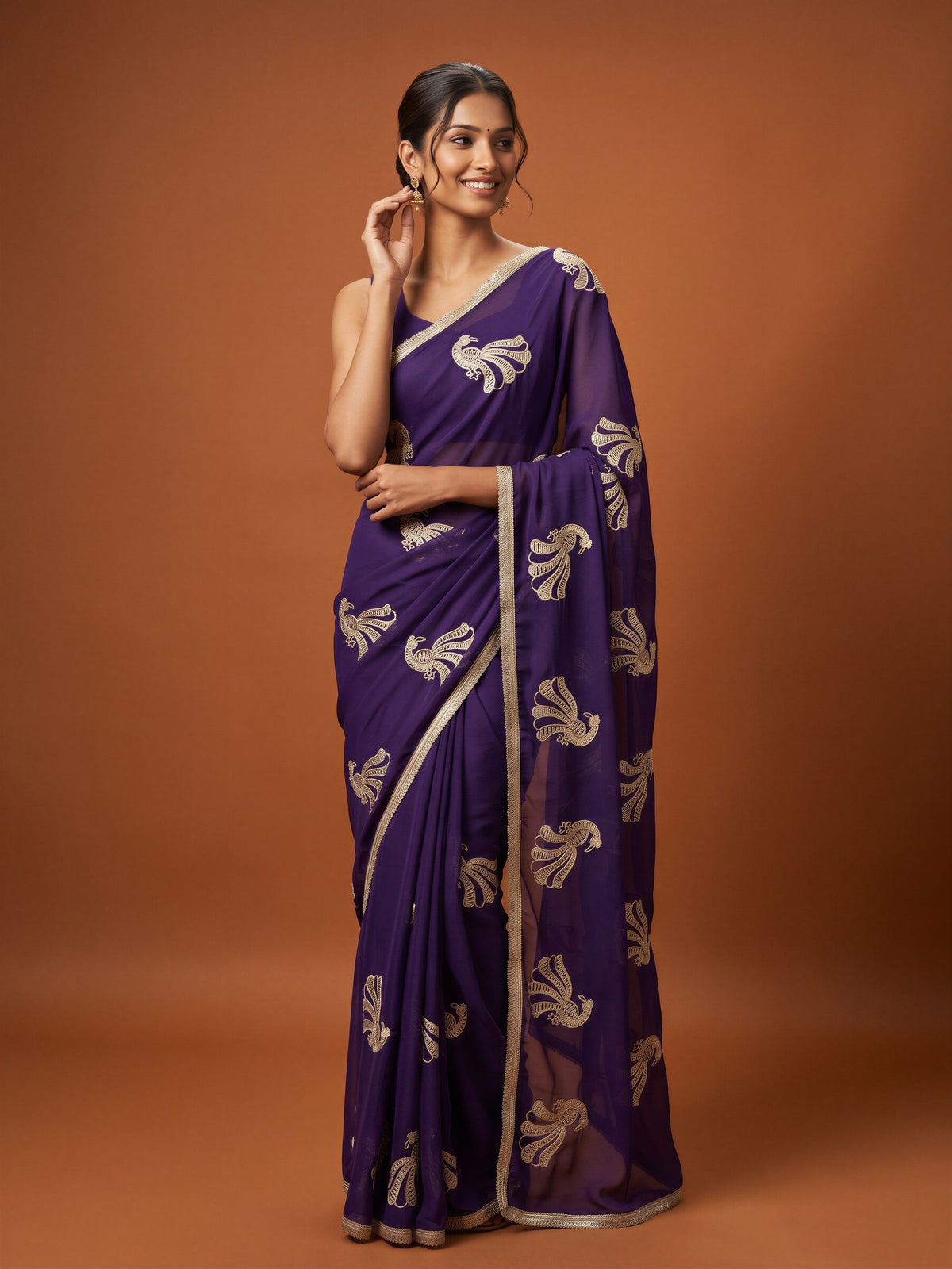 Woman wearing purple georgette saree with embroidered motif work and purple blouse