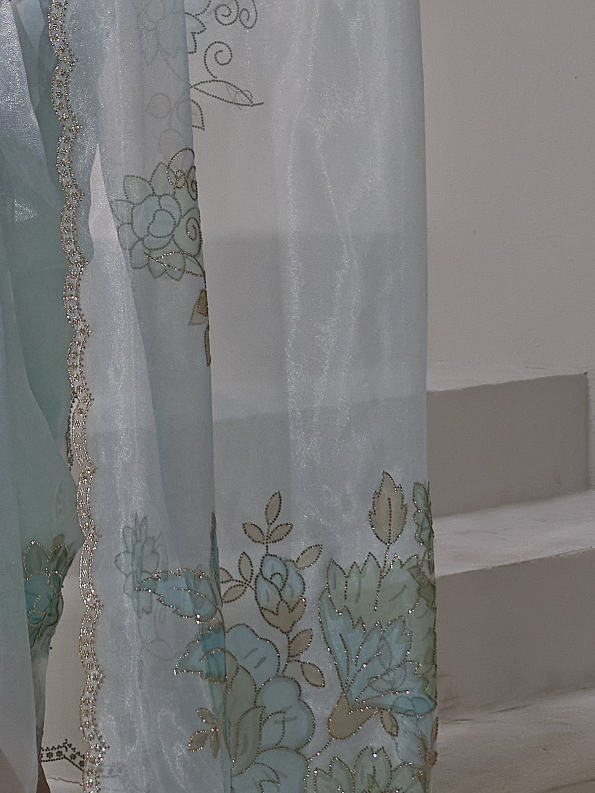 Pallu detail of light blue organza saree showing ornamented surface design and embellished border