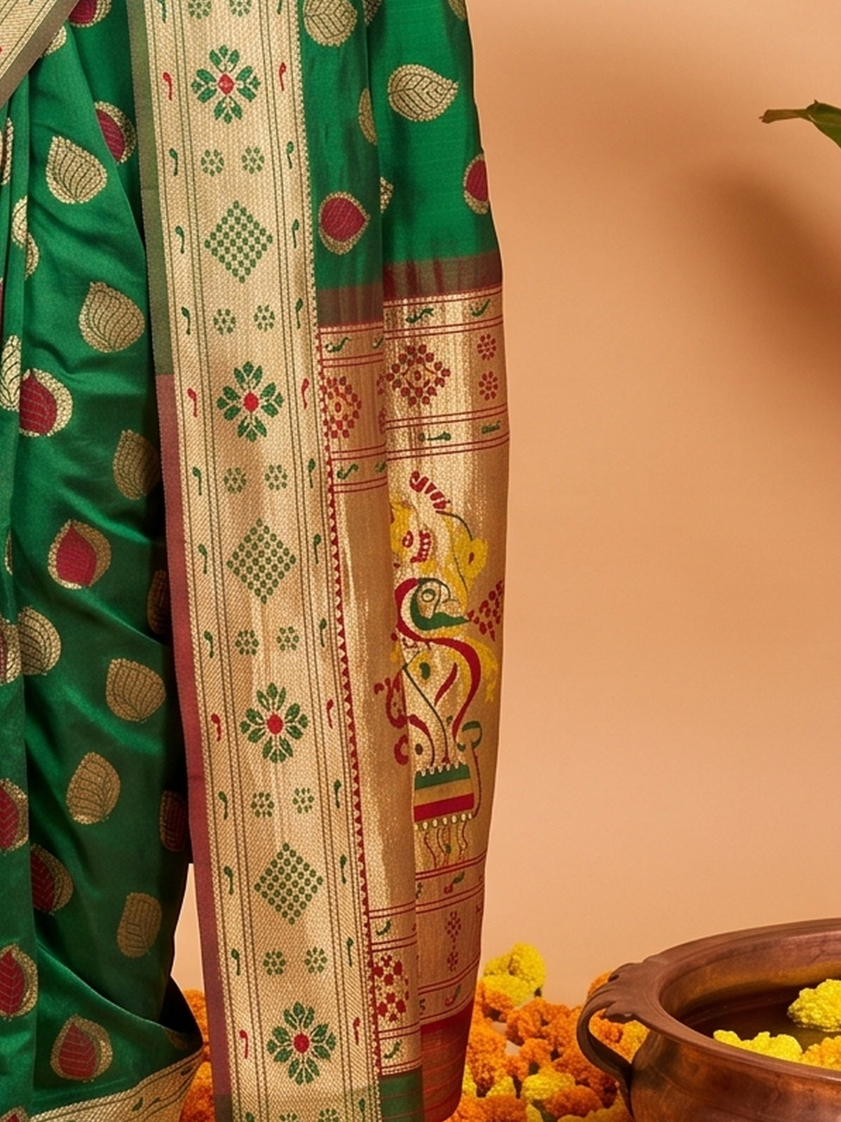 Pallu detail of green silk blend saree showing zari butta (metallic motif) work and zari border