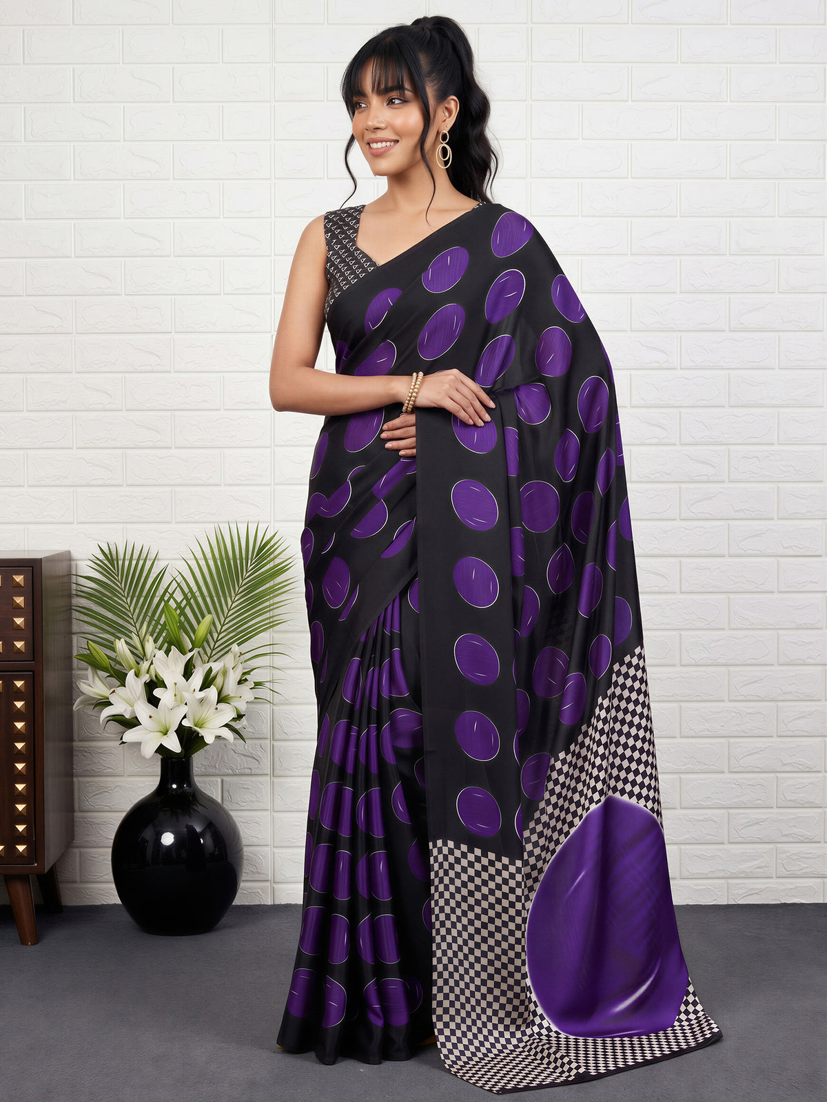 Woman wearing purple satin saree with traditional indian motif work and black blouse